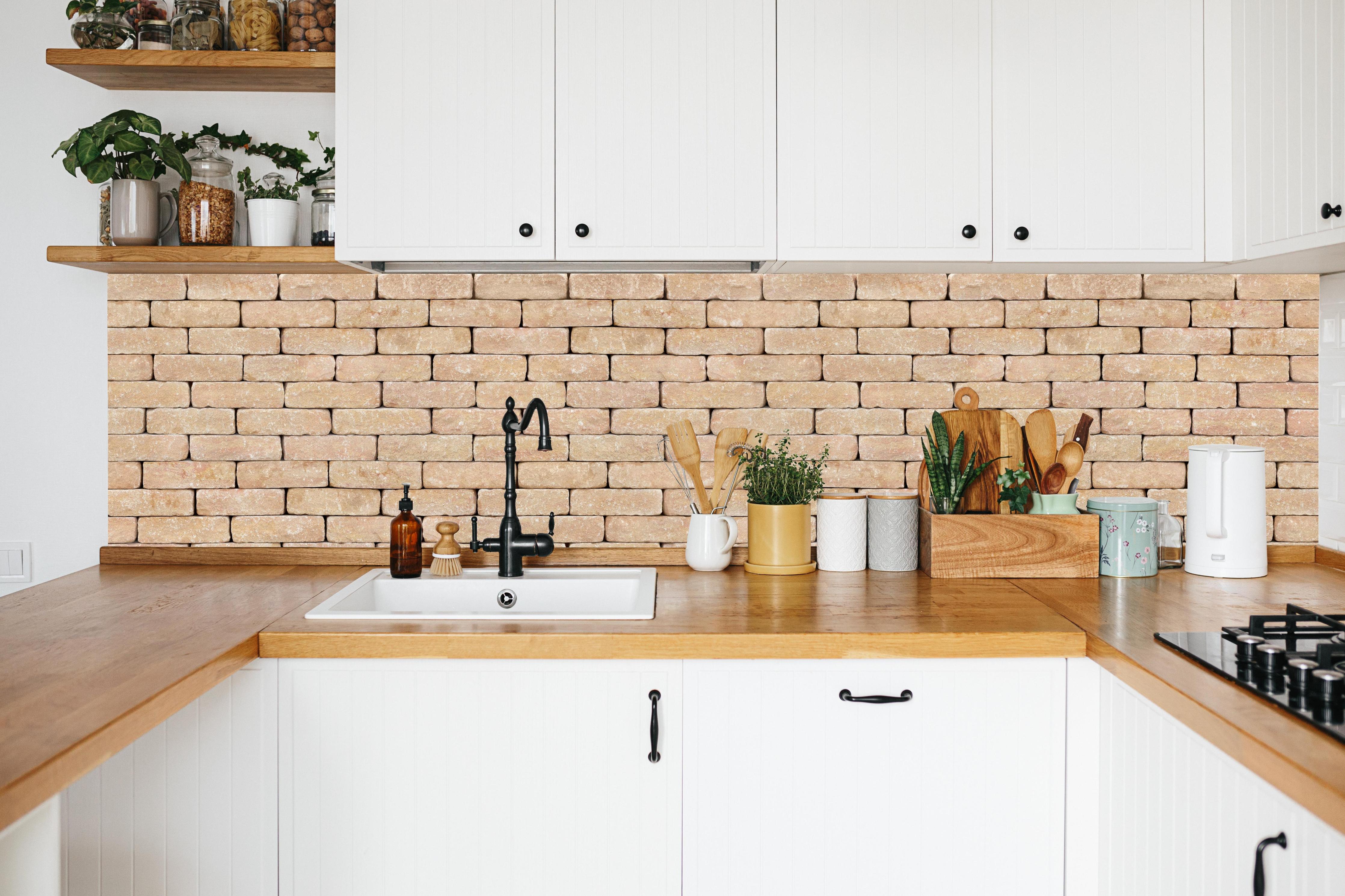Küche - Beige Ziegelwand Textur in weißer Küche hinter Gewürzen und Kochlöffeln aus Holz