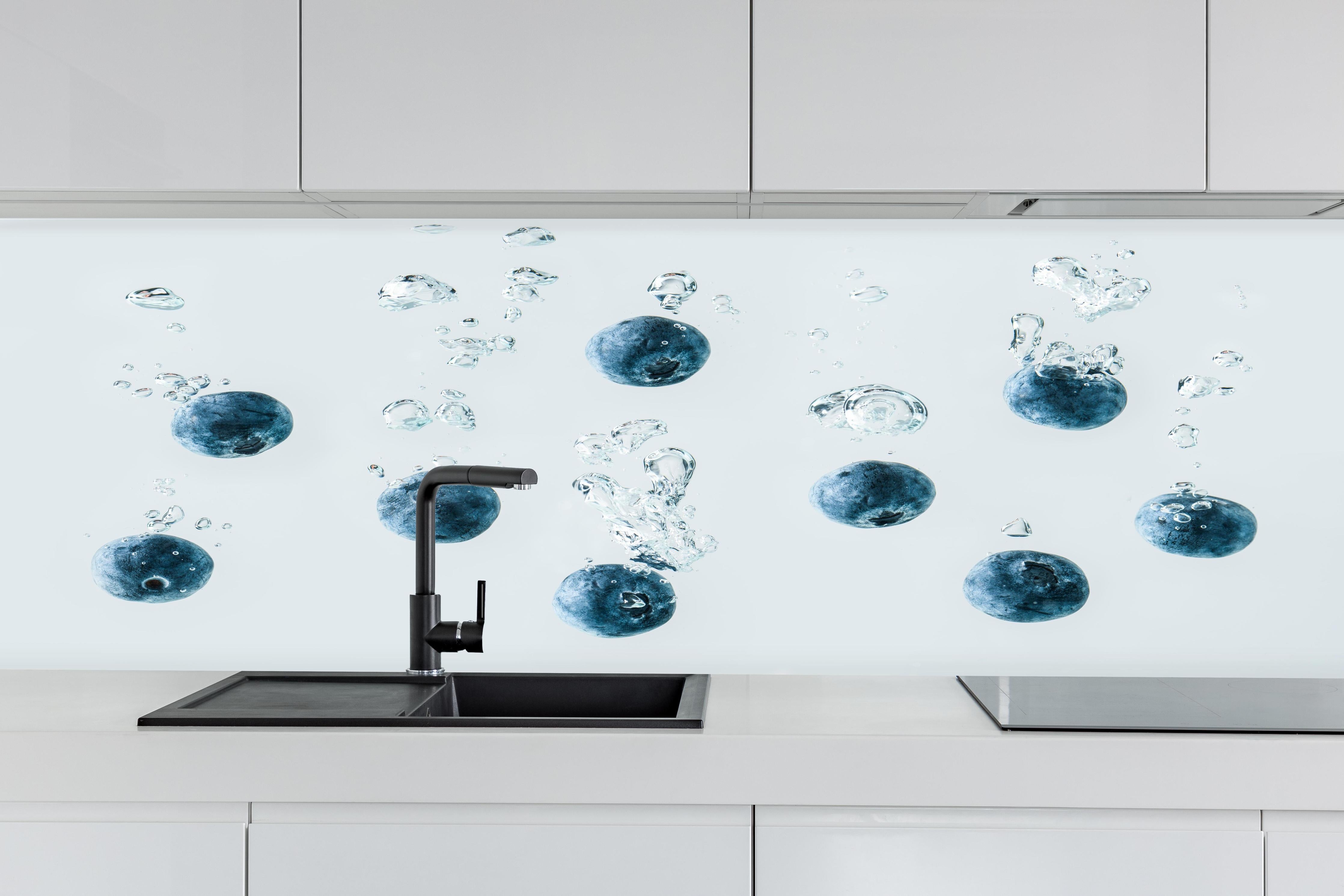 Küche - Blaubeeren im Wassertropfen hinter weißen Hochglanz-Küchenregalen und schwarzem Wasserhahn