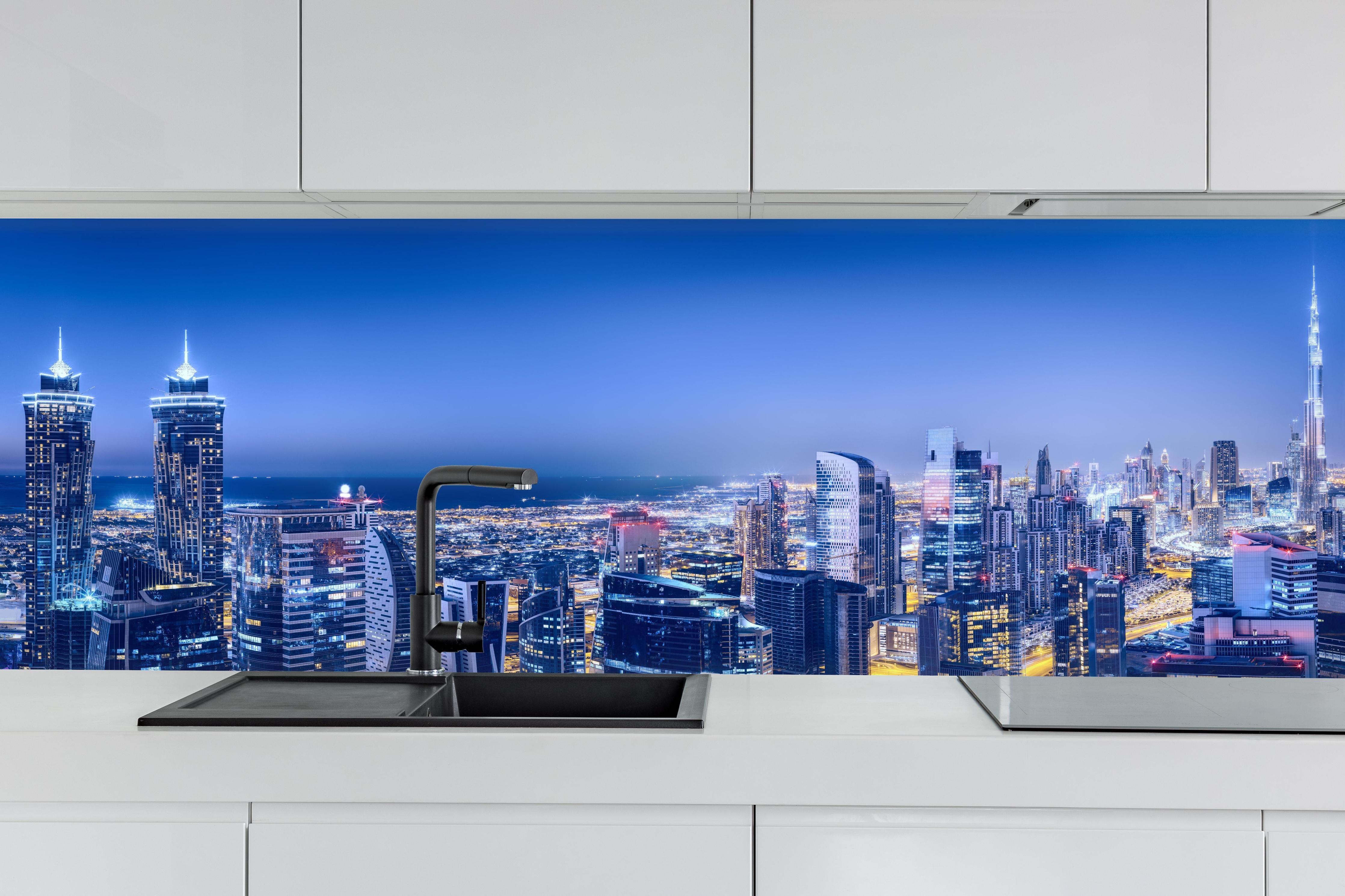 Küche - Blaue Skyline bei Nacht hinter weißen Hochglanz-Küchenregalen und schwarzem Wasserhahn