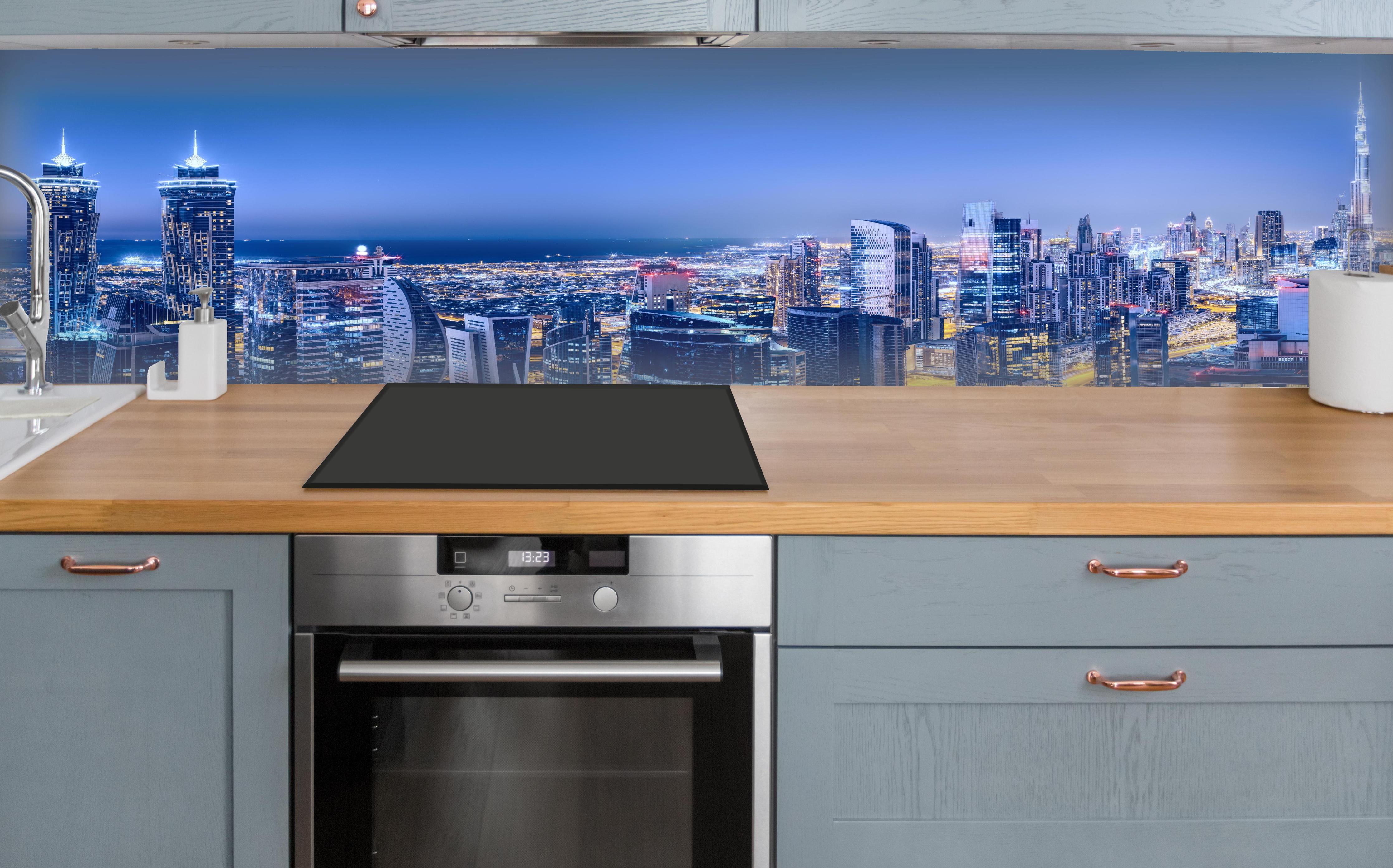 Küche - Blaue Skyline bei Nacht über polierter Holzarbeitsplatte mit Cerankochfeld