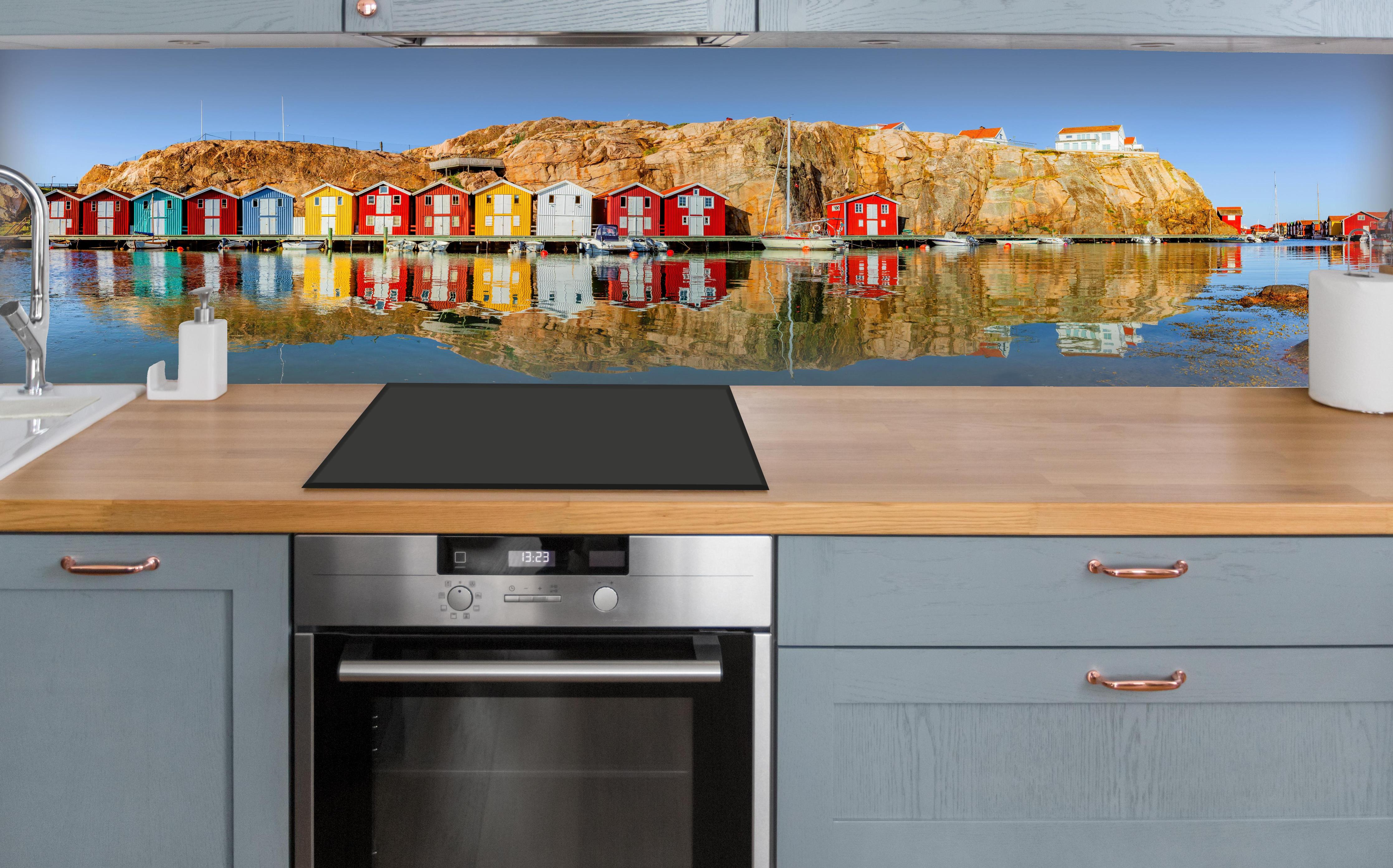 Küche - Bunte Fischerhäuser in Schweden über polierter Holzarbeitsplatte mit Cerankochfeld