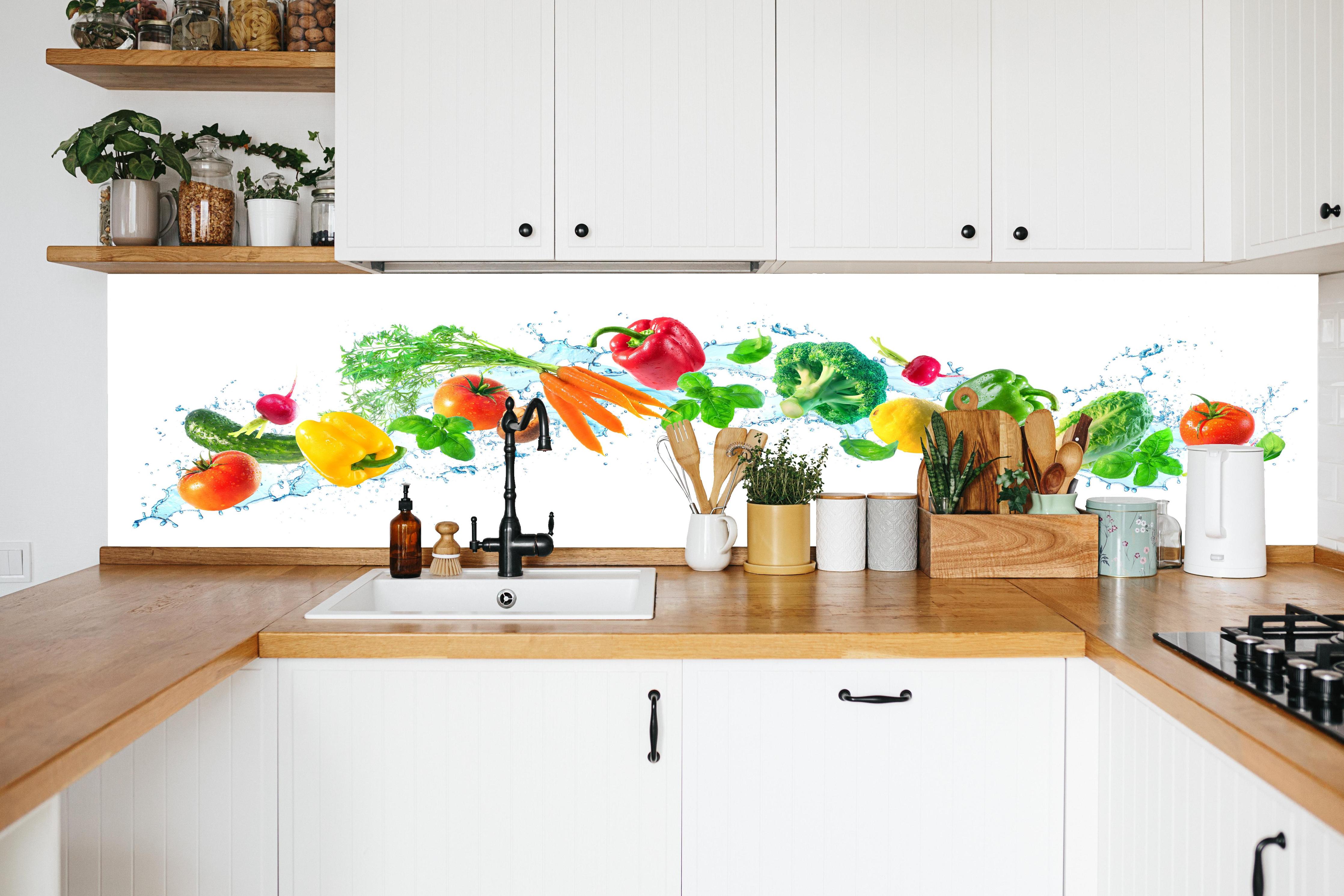 Küche - Bunte Gemüse- und Kräuterkomposition in weißer Küche hinter Gewürzen und Kochlöffeln aus Holz