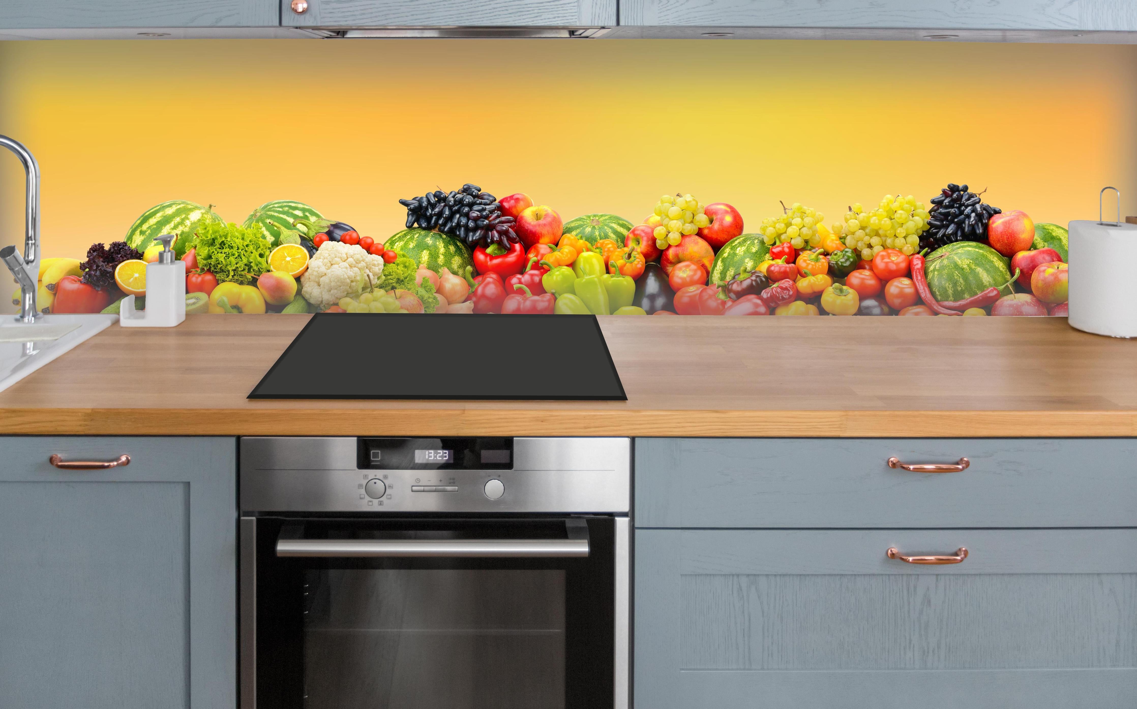 Küche - Buntes Obst & Gemüse-Stillleben über polierter Holzarbeitsplatte mit Cerankochfeld