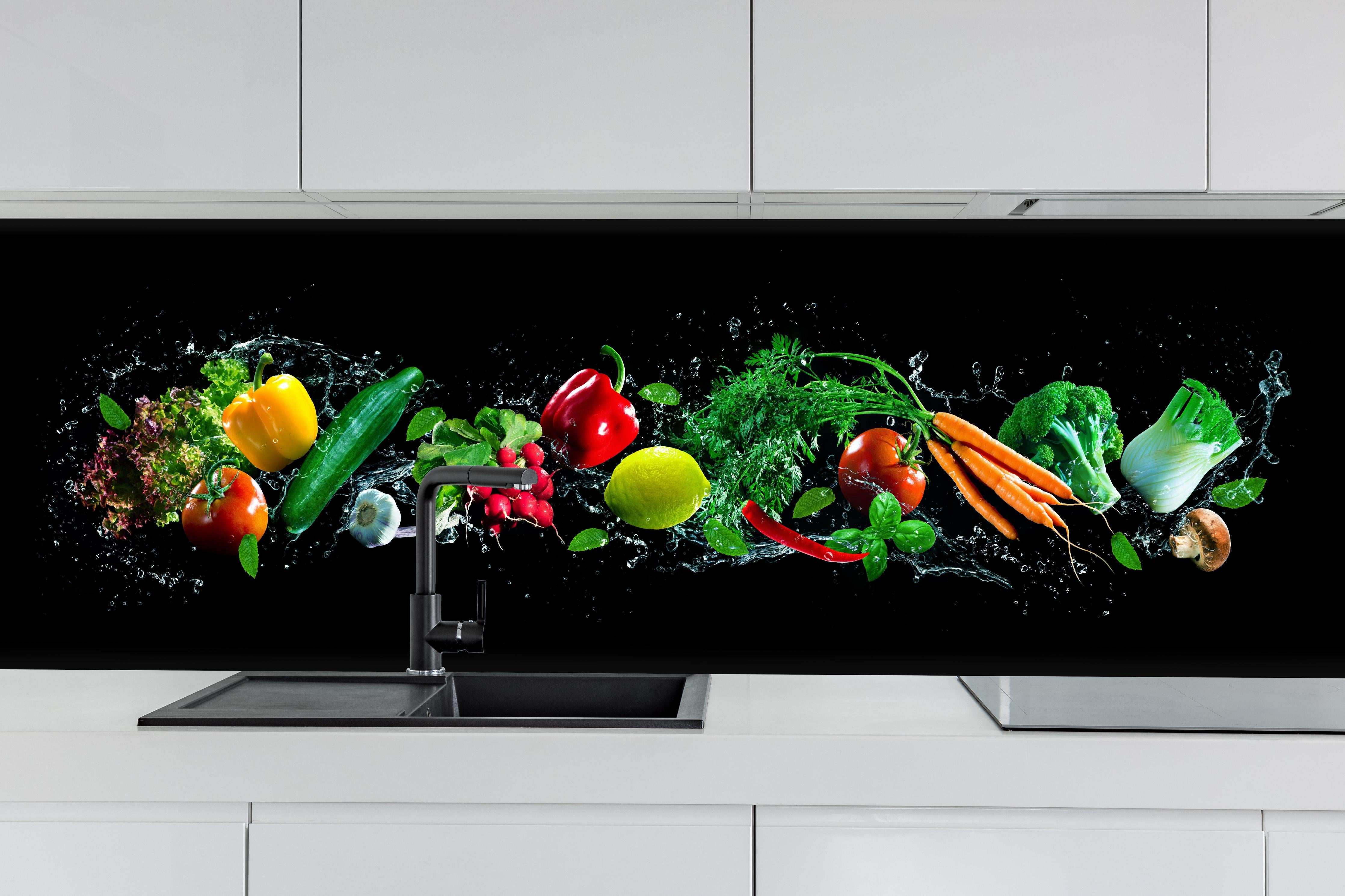 Küche - Buntes Obst auf schwarzem Hintergrund hinter weißen Hochglanz-Küchenregalen und schwarzem Wasserhahn