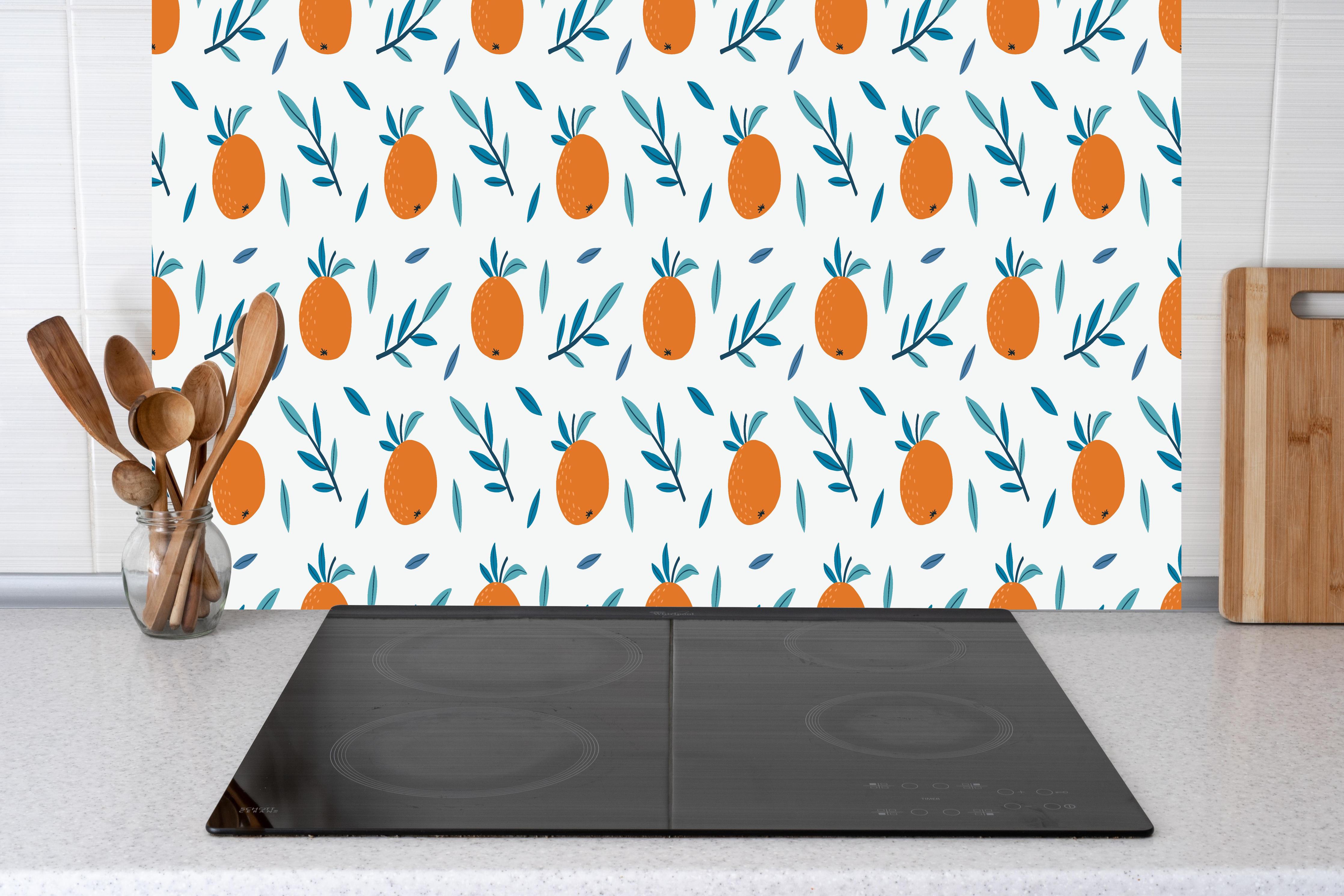 Küche - Citrus Orange Muster hinter Cerankochfeld und Holz-Kochutensilien