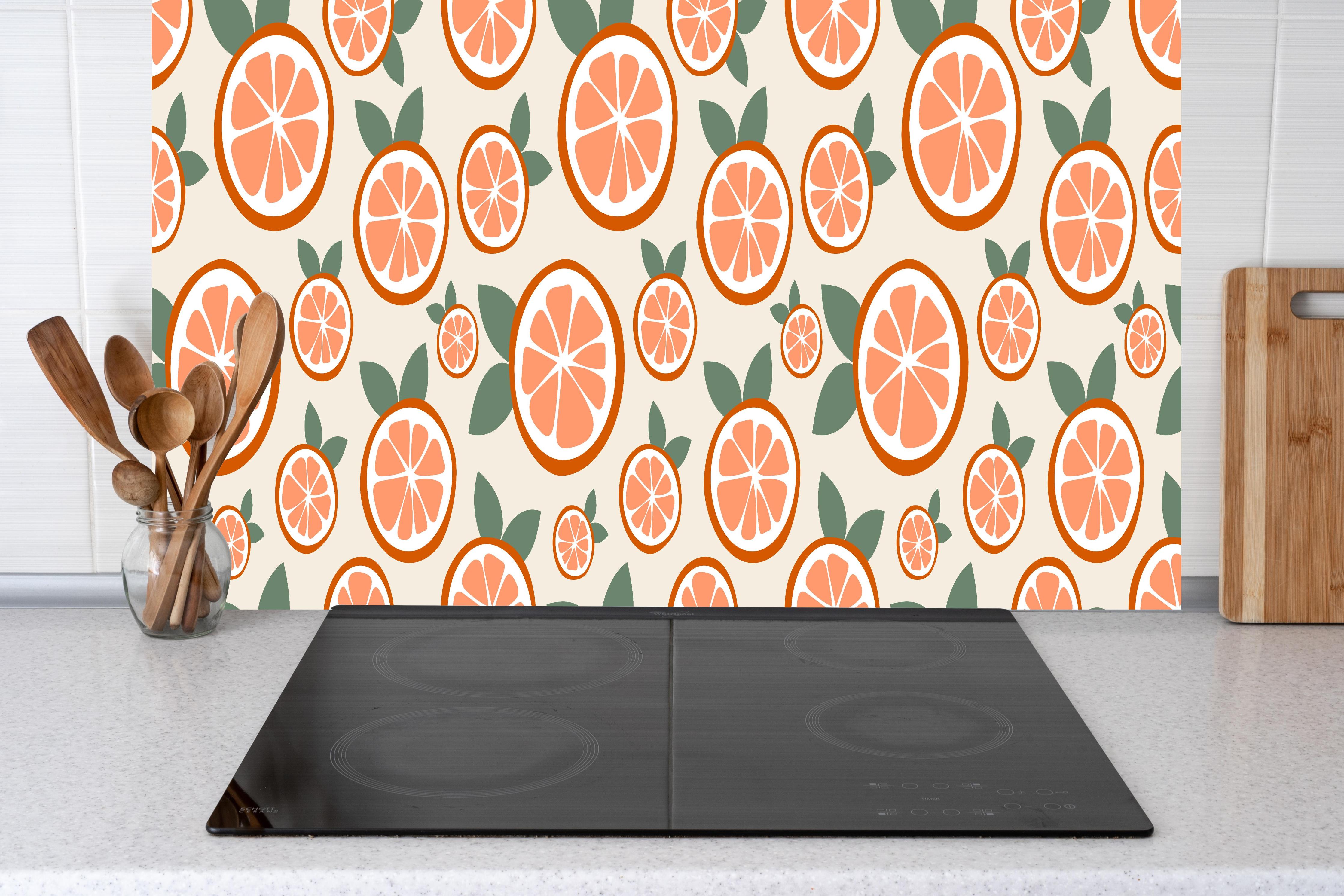 Küche - Citrus Orangenmuster Timeless Slice hinter Cerankochfeld und Holz-Kochutensilien