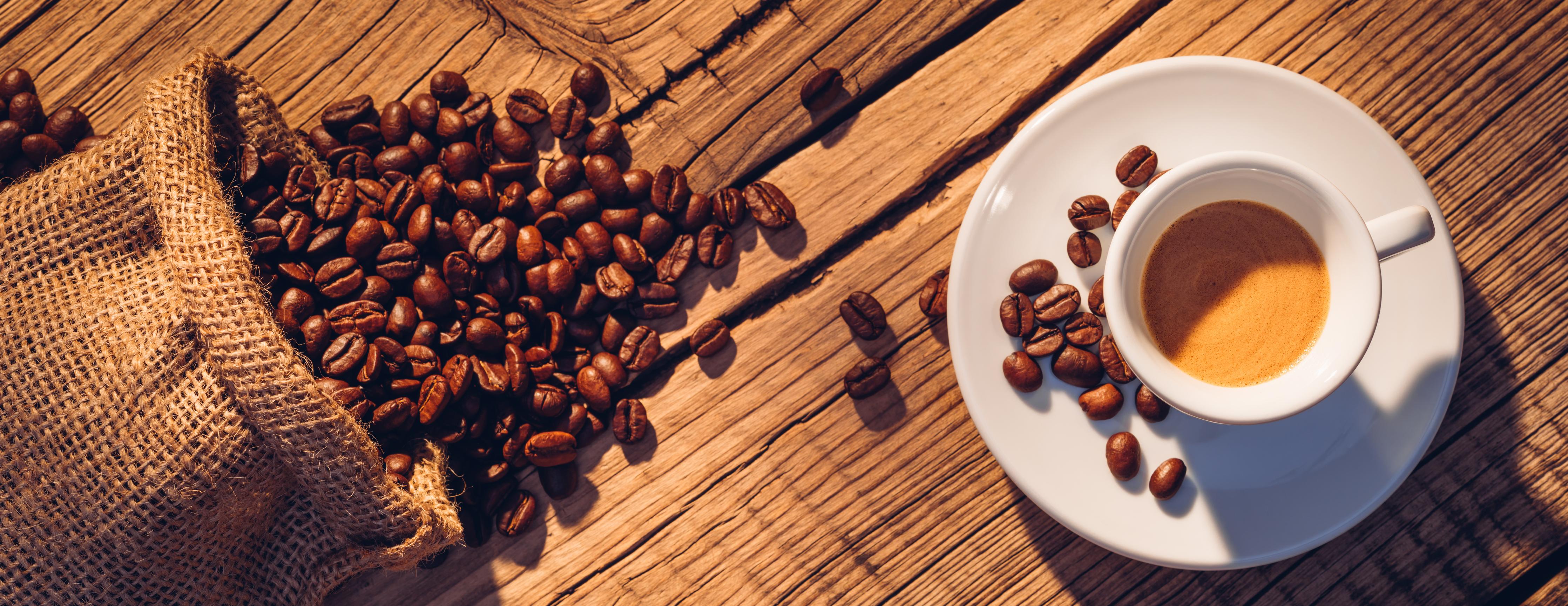 Küchenrückwand-Espresso und Kaffeebohnen auf Holz