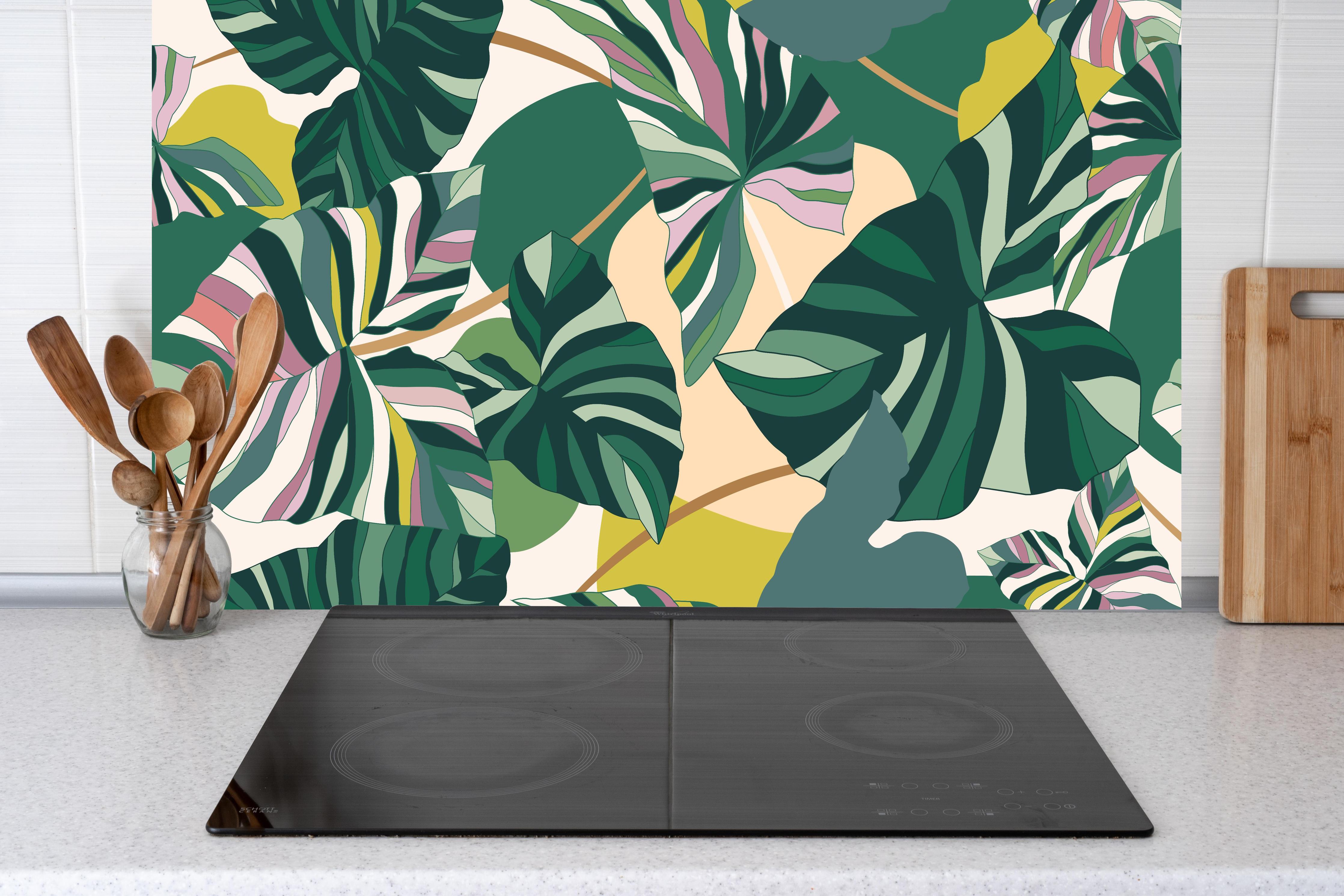 Küche - Exotisches Monstera Blattdesign hinter Cerankochfeld und Holz-Kochutensilien