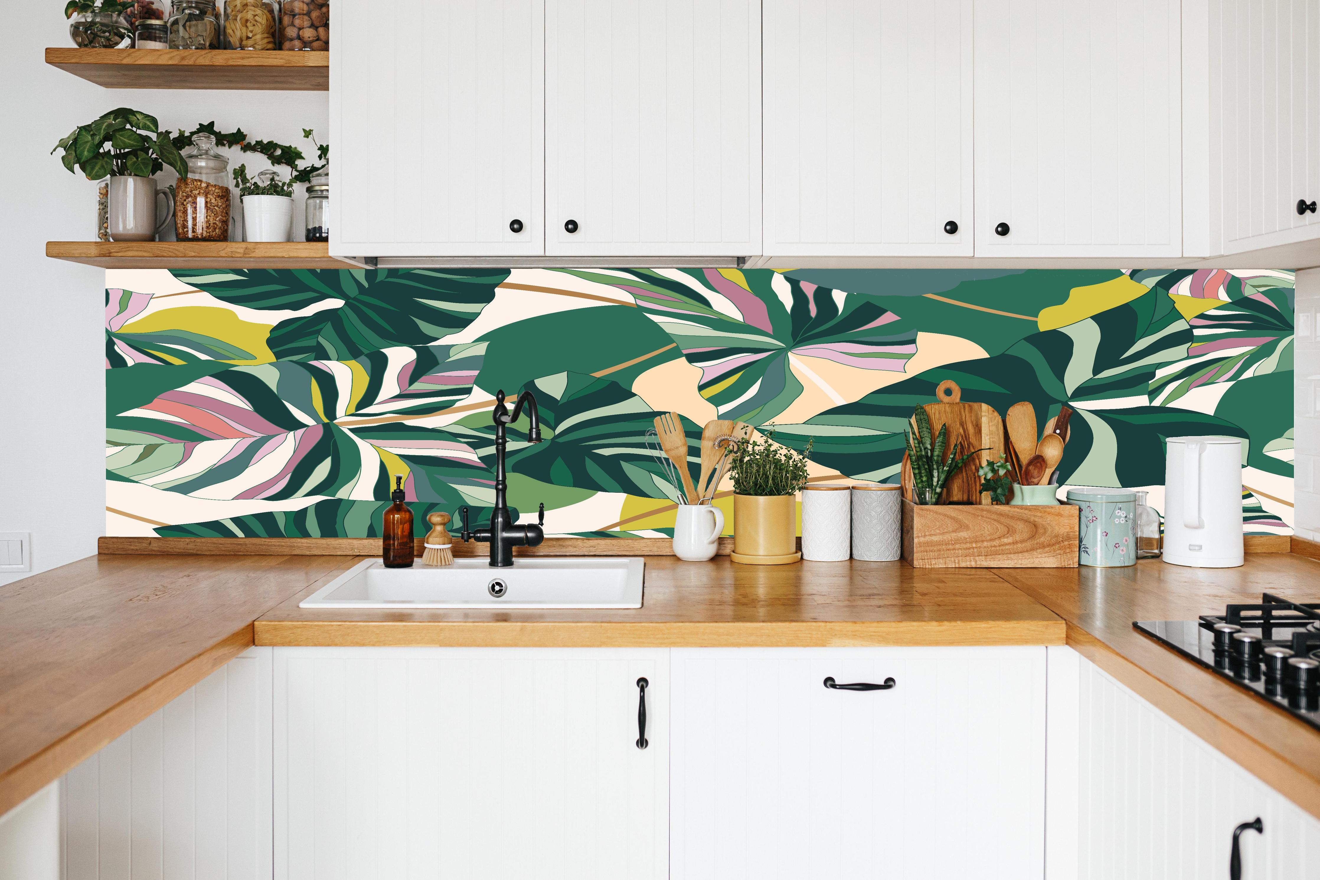 Küche - Exotisches Monstera Blattdesign in weißer Küche hinter Gewürzen und Kochlöffeln aus Holz