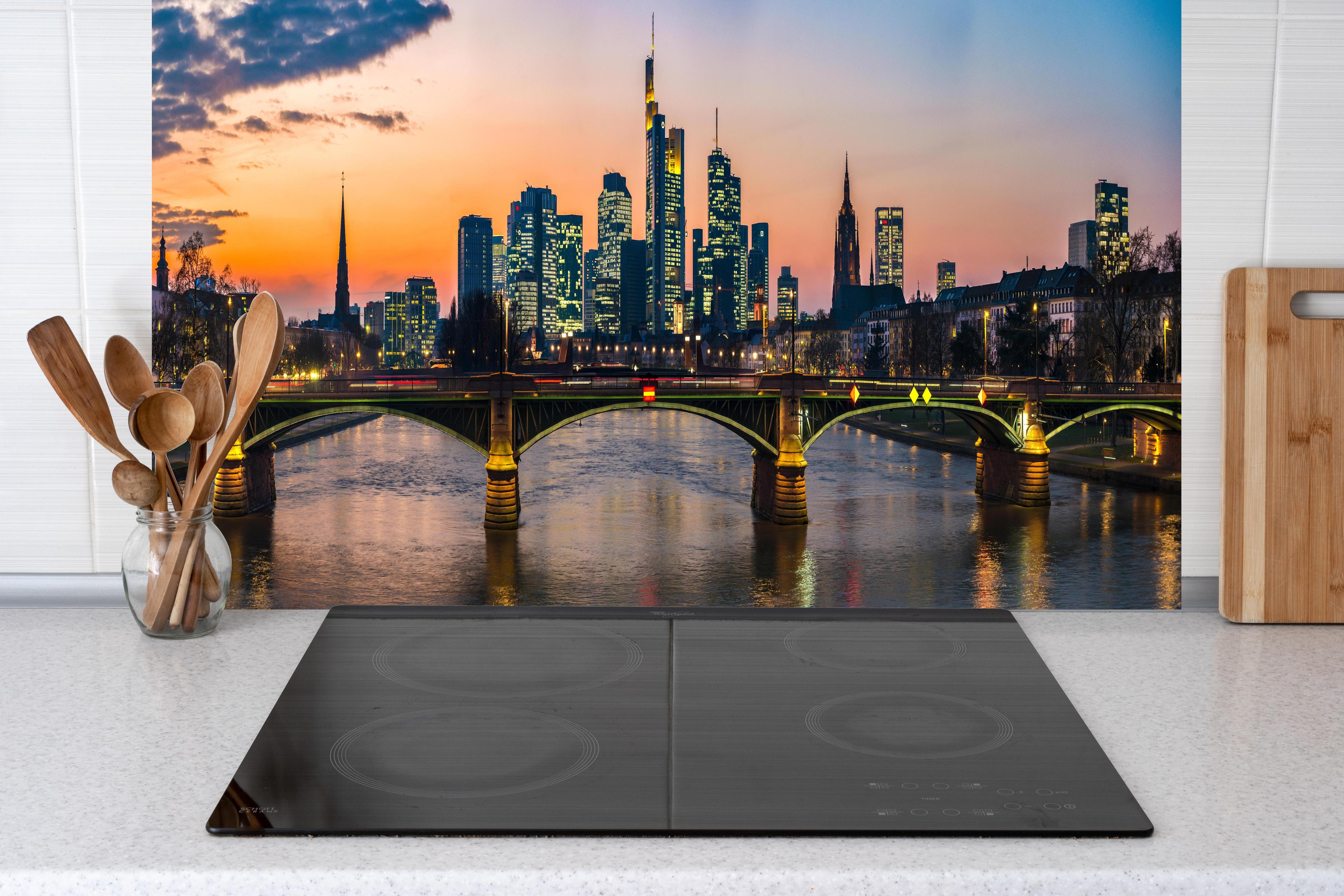 Küche - Frankfurt Skyline Sonnenuntergang hinter Cerankochfeld und Holz-Kochutensilien