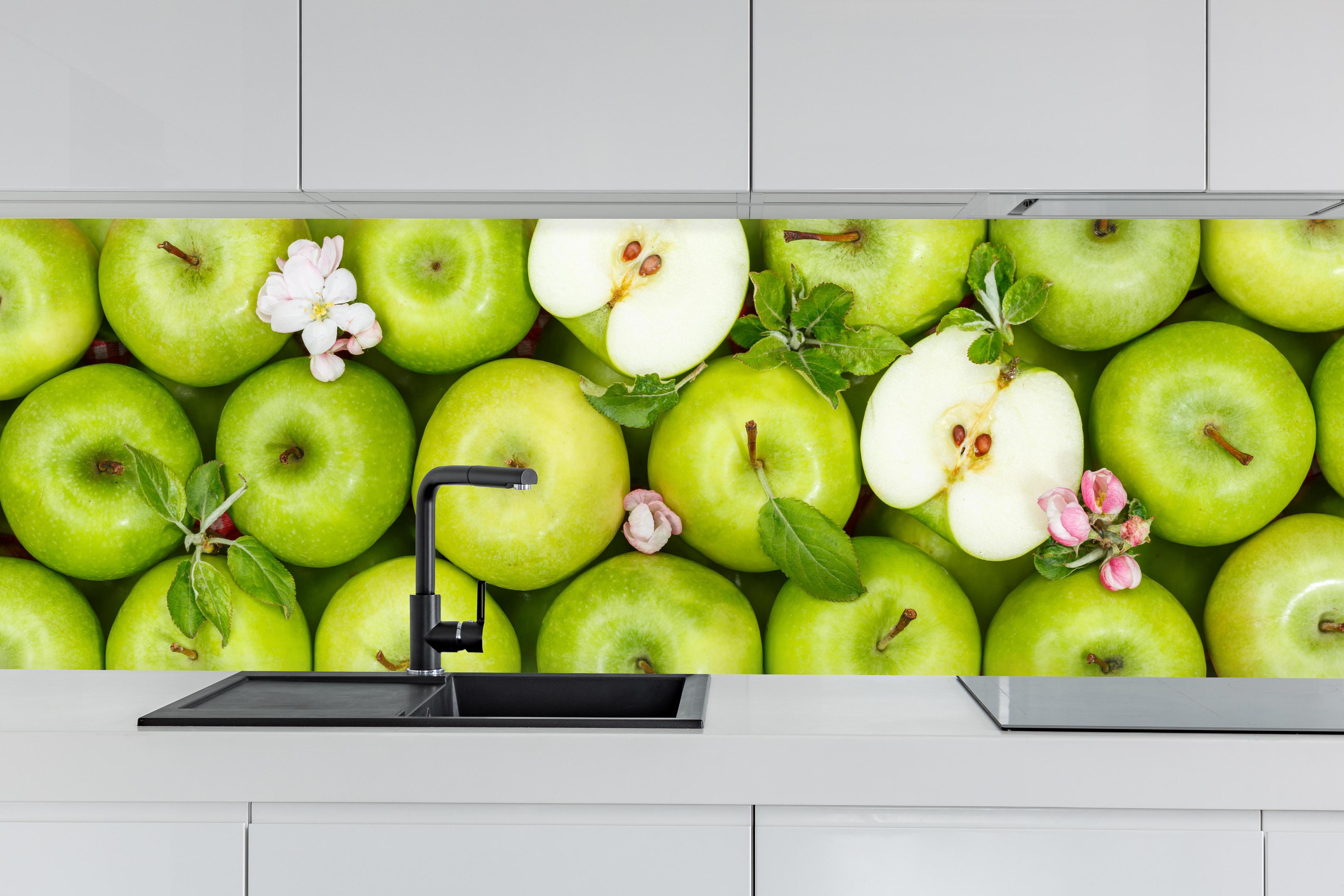 Küche - Frische grüne Äpfel hinter weißen Hochglanz-Küchenregalen und schwarzem Wasserhahn