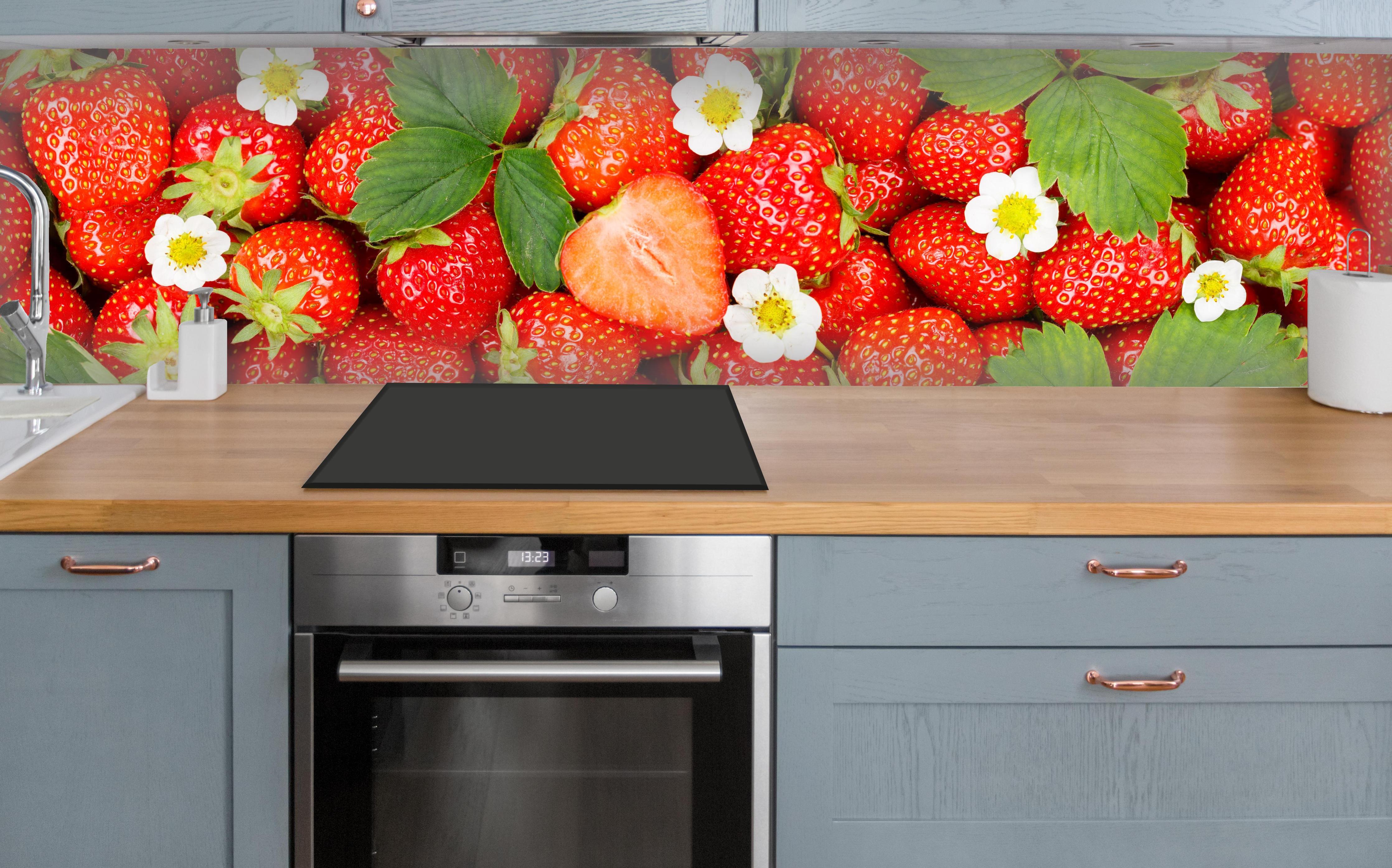 Küche - Frische rote Erdbeeren über polierter Holzarbeitsplatte mit Cerankochfeld