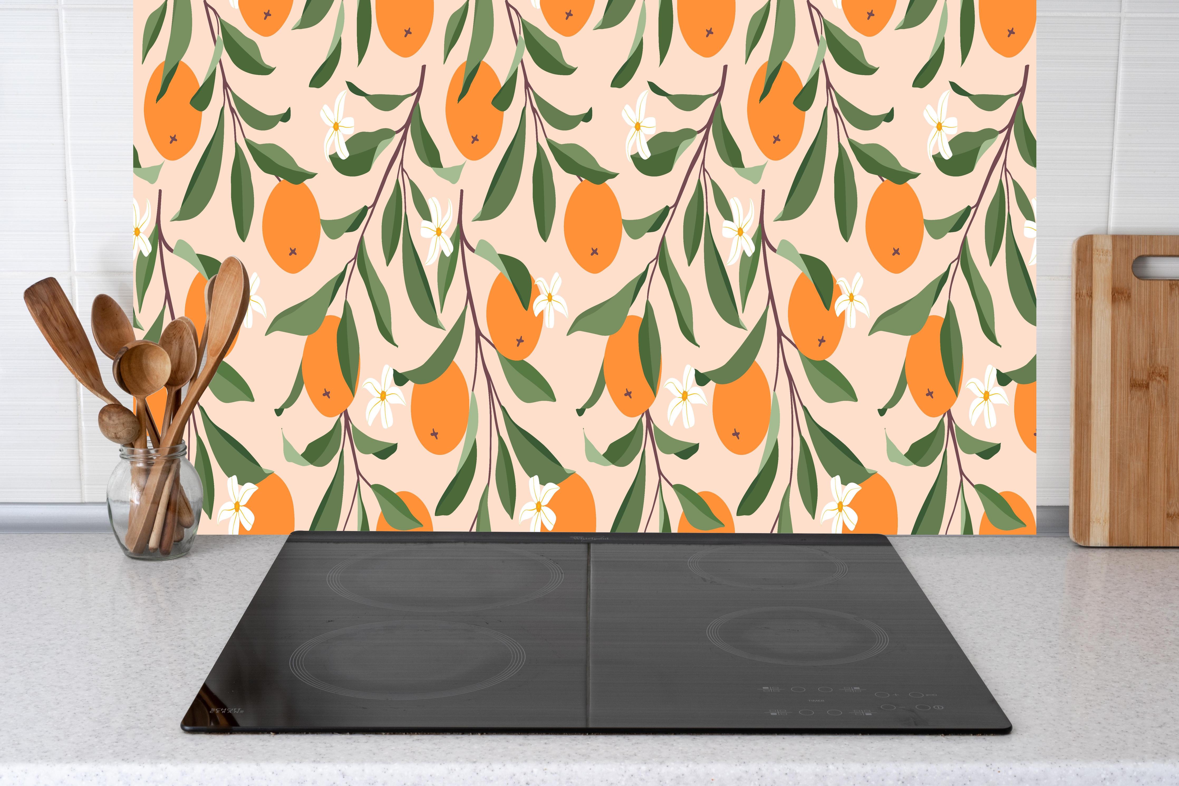 Küche - Fruchtiges Citrus-Orange Design hinter Cerankochfeld und Holz-Kochutensilien