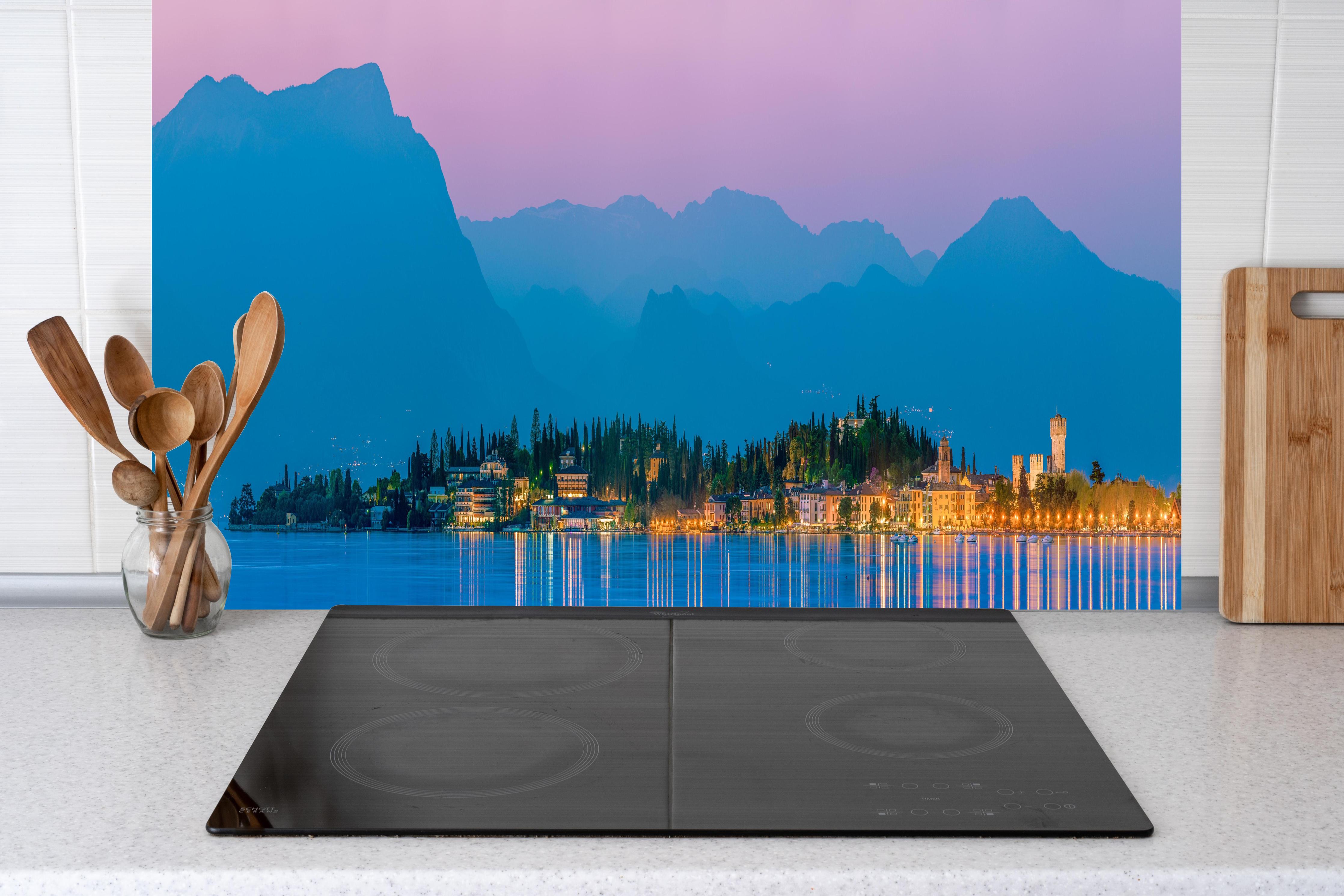 Küche - Gardasee Abenddämmerung Panorama hinter Cerankochfeld und Holz-Kochutensilien