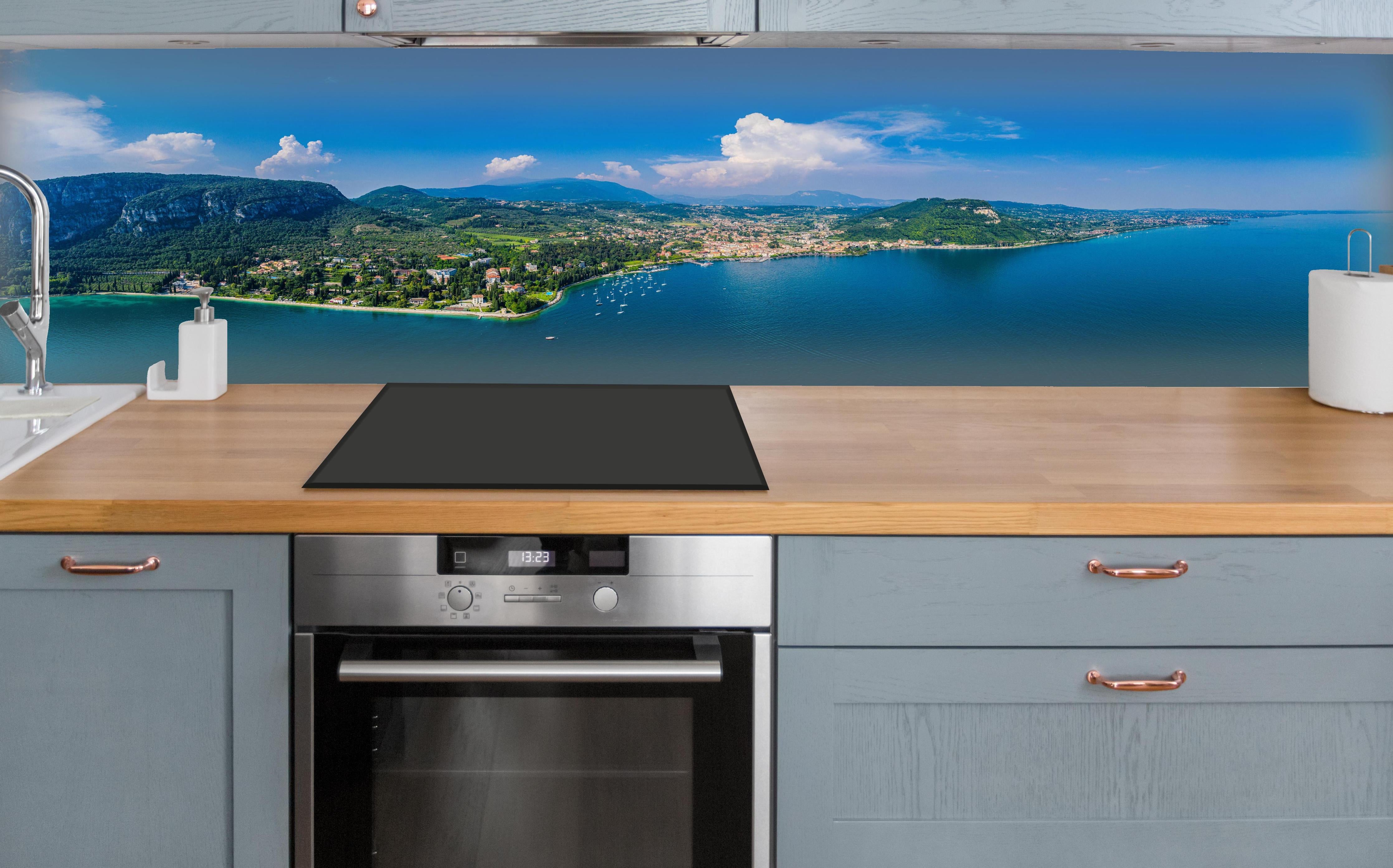 Küche - Gardasee Panorama Blau-Grün über polierter Holzarbeitsplatte mit Cerankochfeld