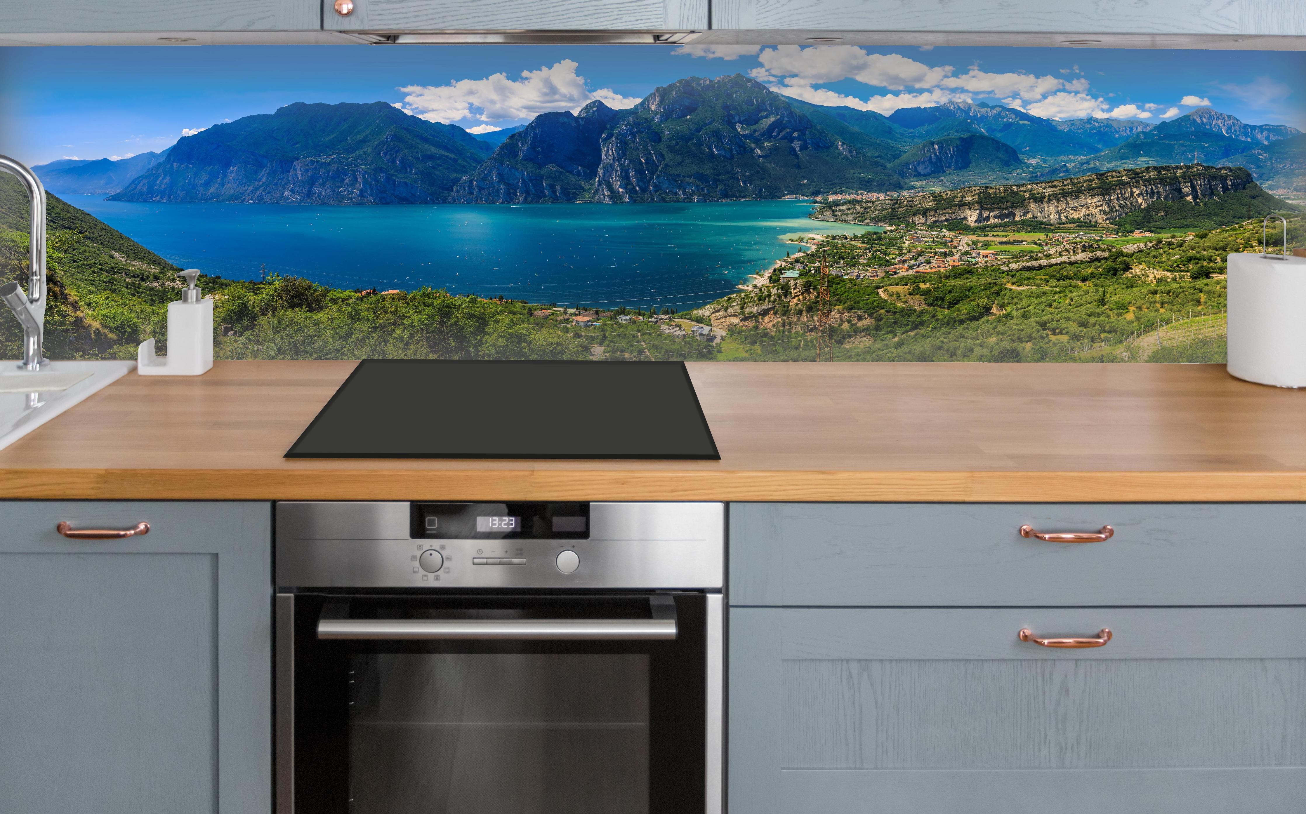 Küche - Gardasee Panorama in Blau und Grün über polierter Holzarbeitsplatte mit Cerankochfeld