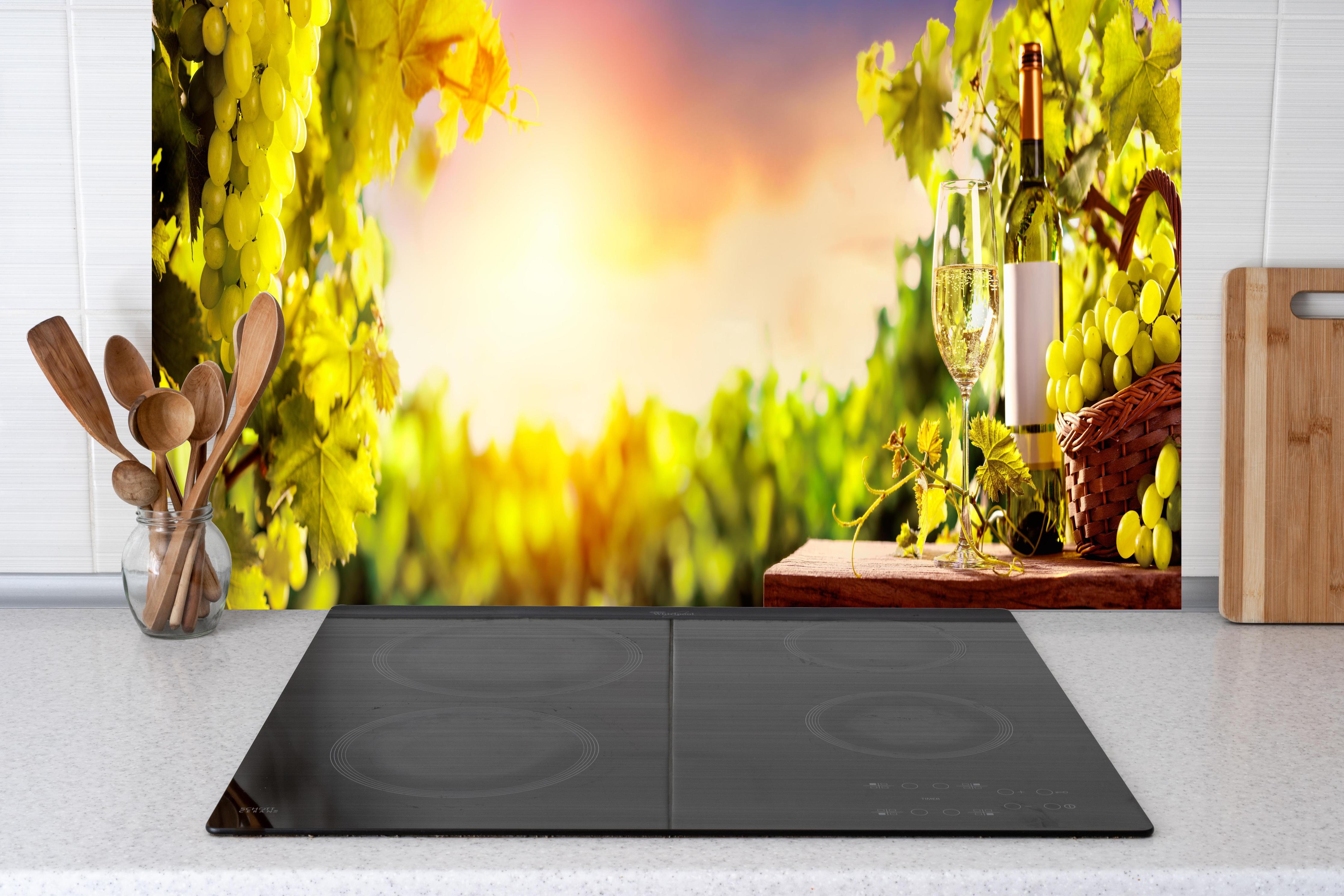 Küche - Goldgrüner Weinberg bei Sonnenuntergang hinter Cerankochfeld und Holz-Kochutensilien