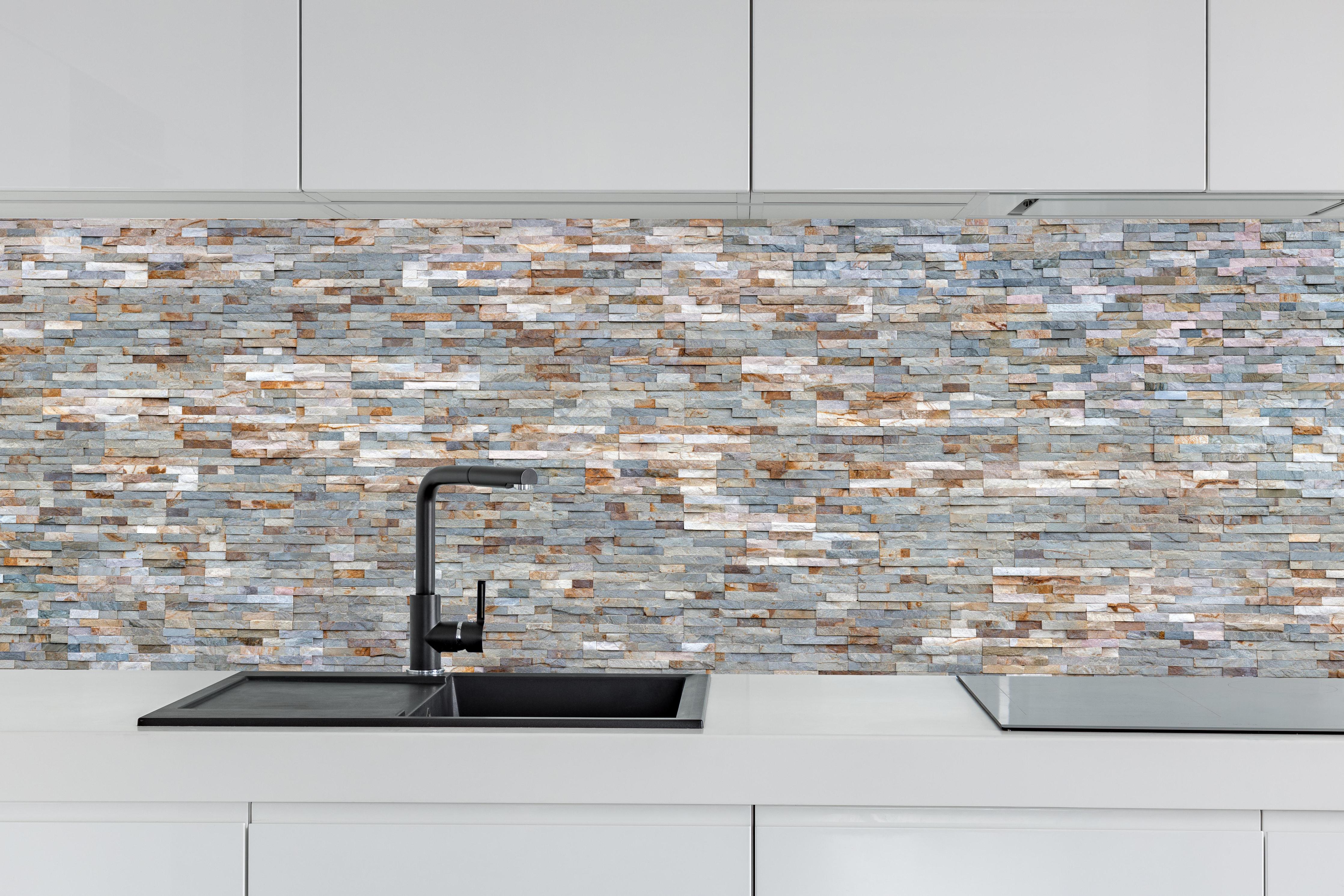 Küche - Grau-Beige Steinmauer Textur hinter weißen Hochglanz-Küchenregalen und schwarzem Wasserhahn