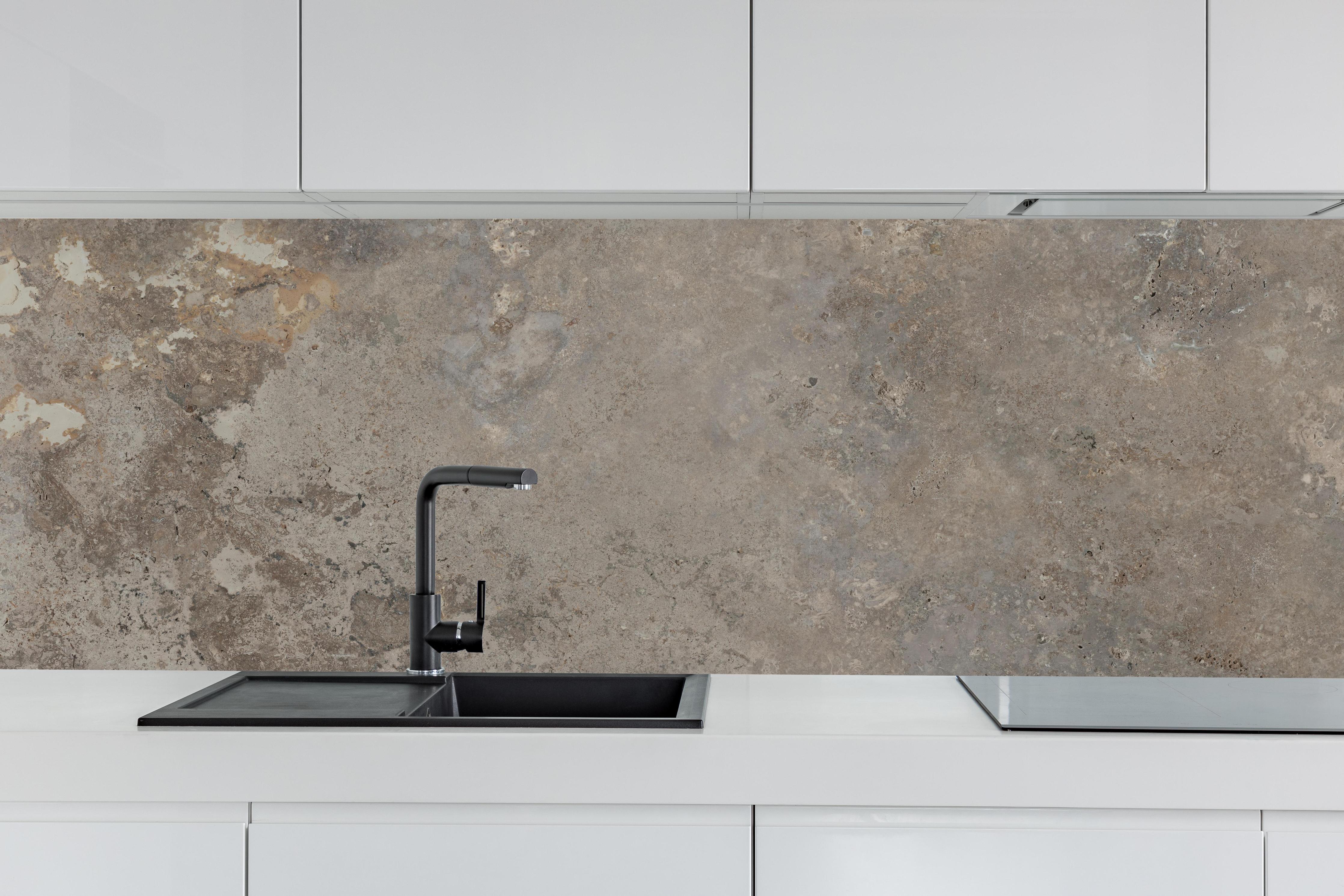 Küche - Grau-Braune Steinwand-Textur hinter weißen Hochglanz-Küchenregalen und schwarzem Wasserhahn