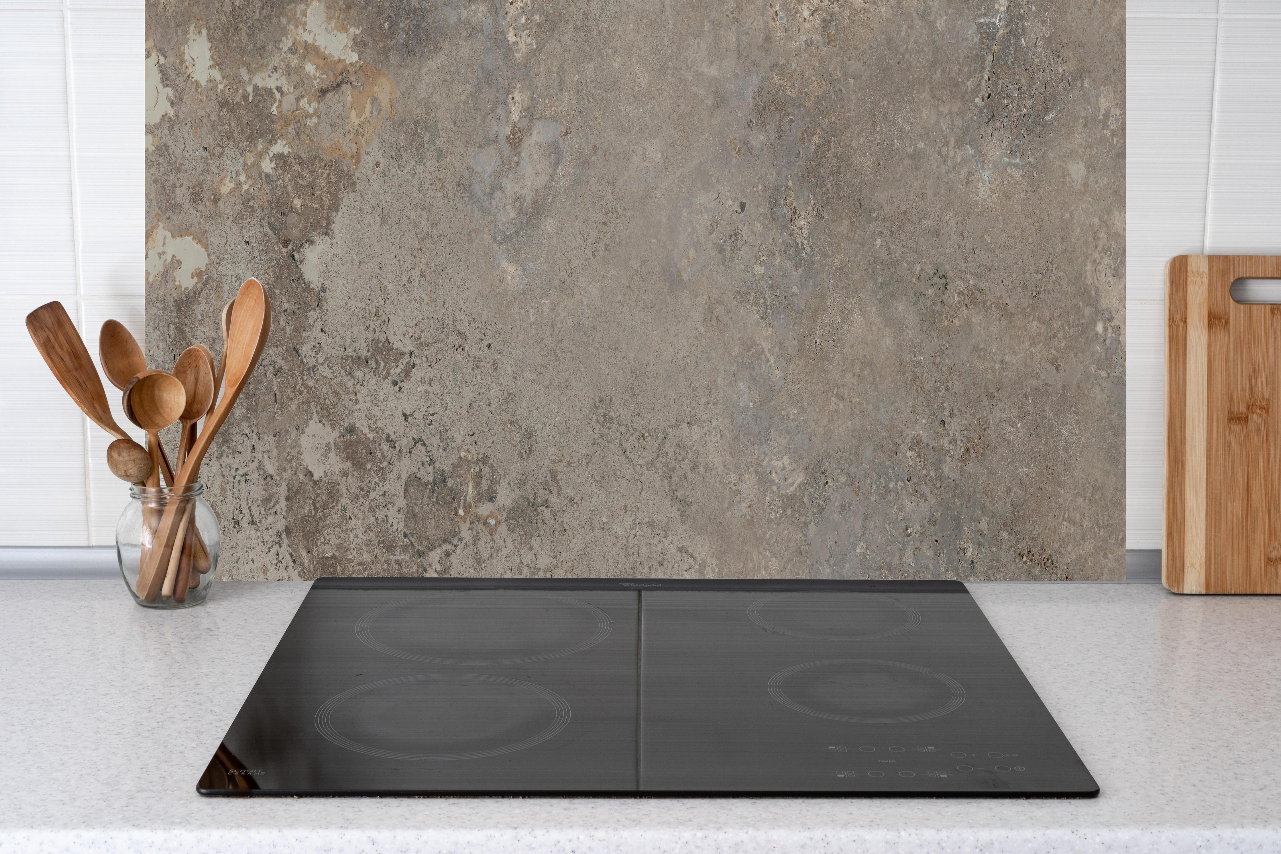 Küche - Grau-Braune Steinwand-Textur hinter Cerankochfeld und Holz-Kochutensilien