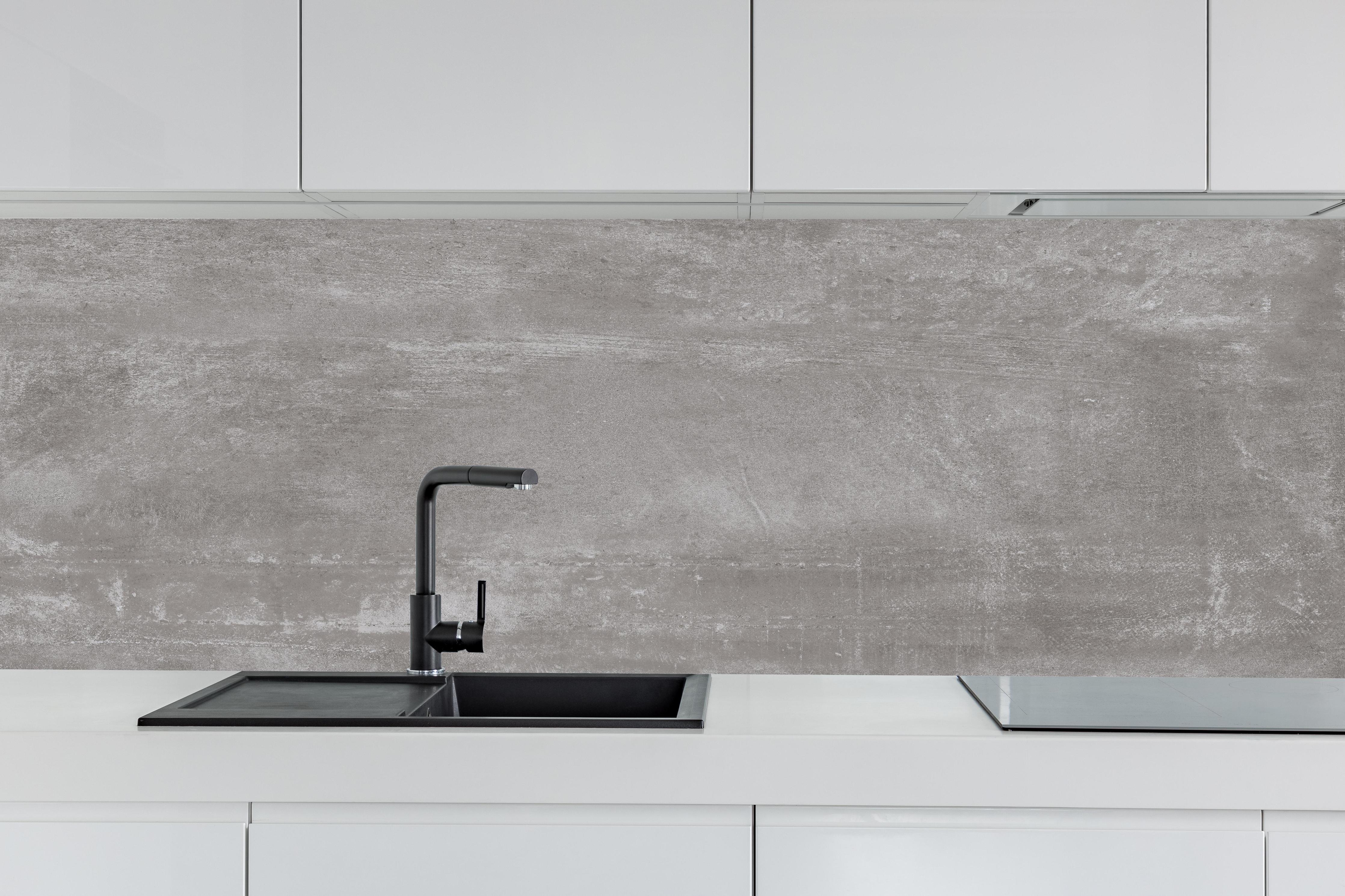 Küche - Graue Beton-Textur hinter weißen Hochglanz-Küchenregalen und schwarzem Wasserhahn