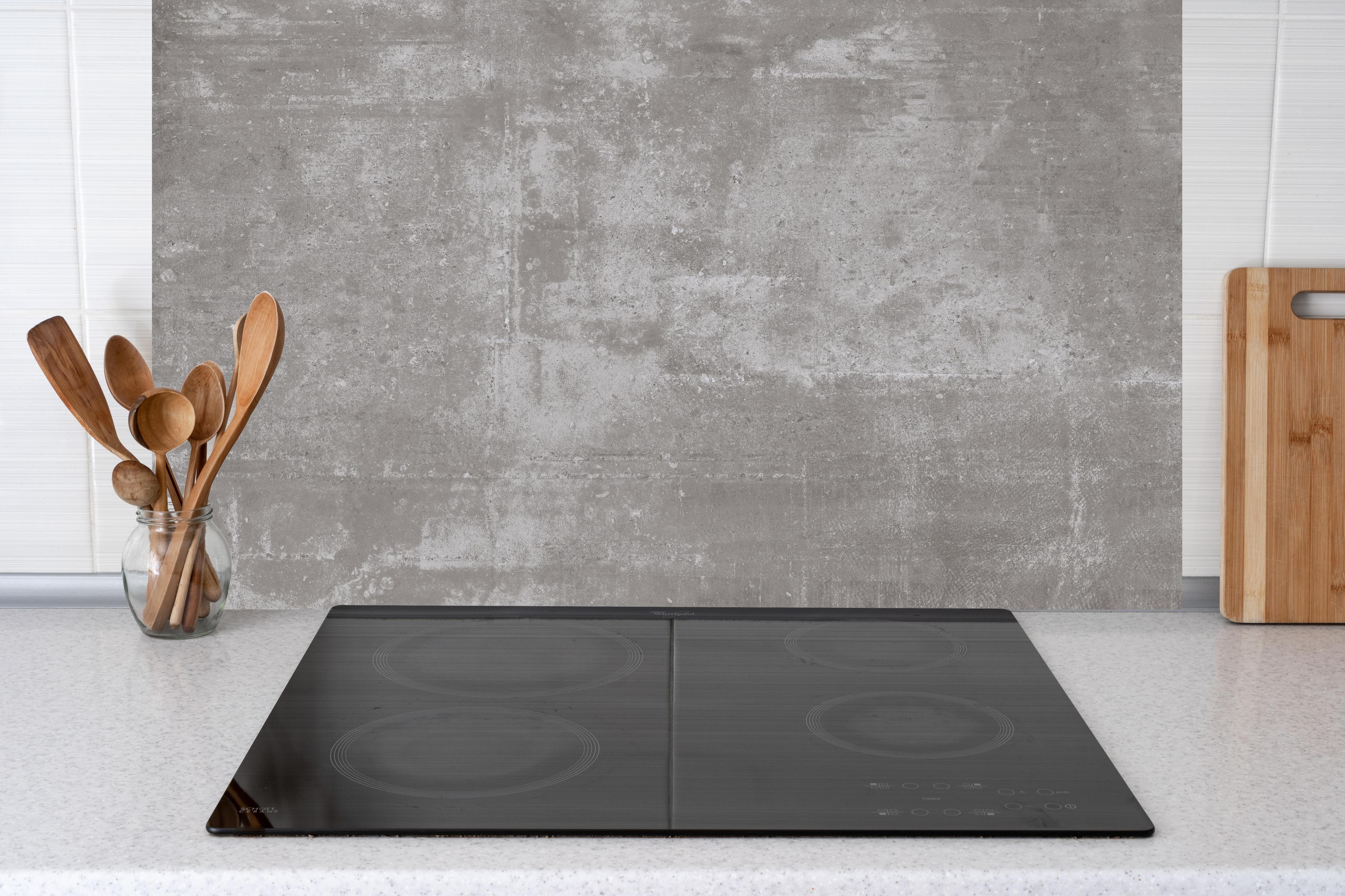 Küche - Graue Betonstruktur Wandtextur hinter Cerankochfeld und Holz-Kochutensilien