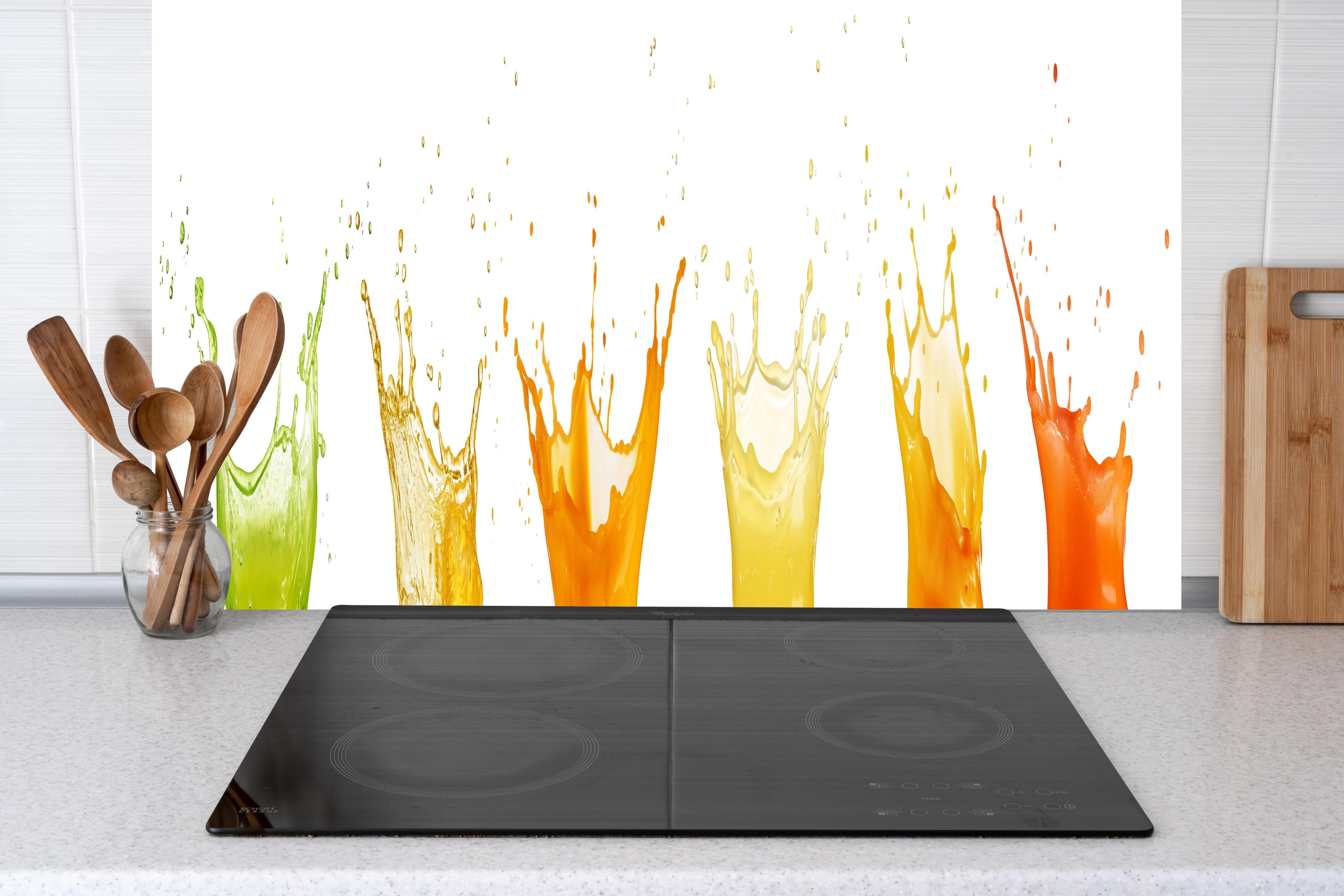 Küche - Grün-Gelb-Orange Wassersplash hinter Cerankochfeld und Holz-Kochutensilien