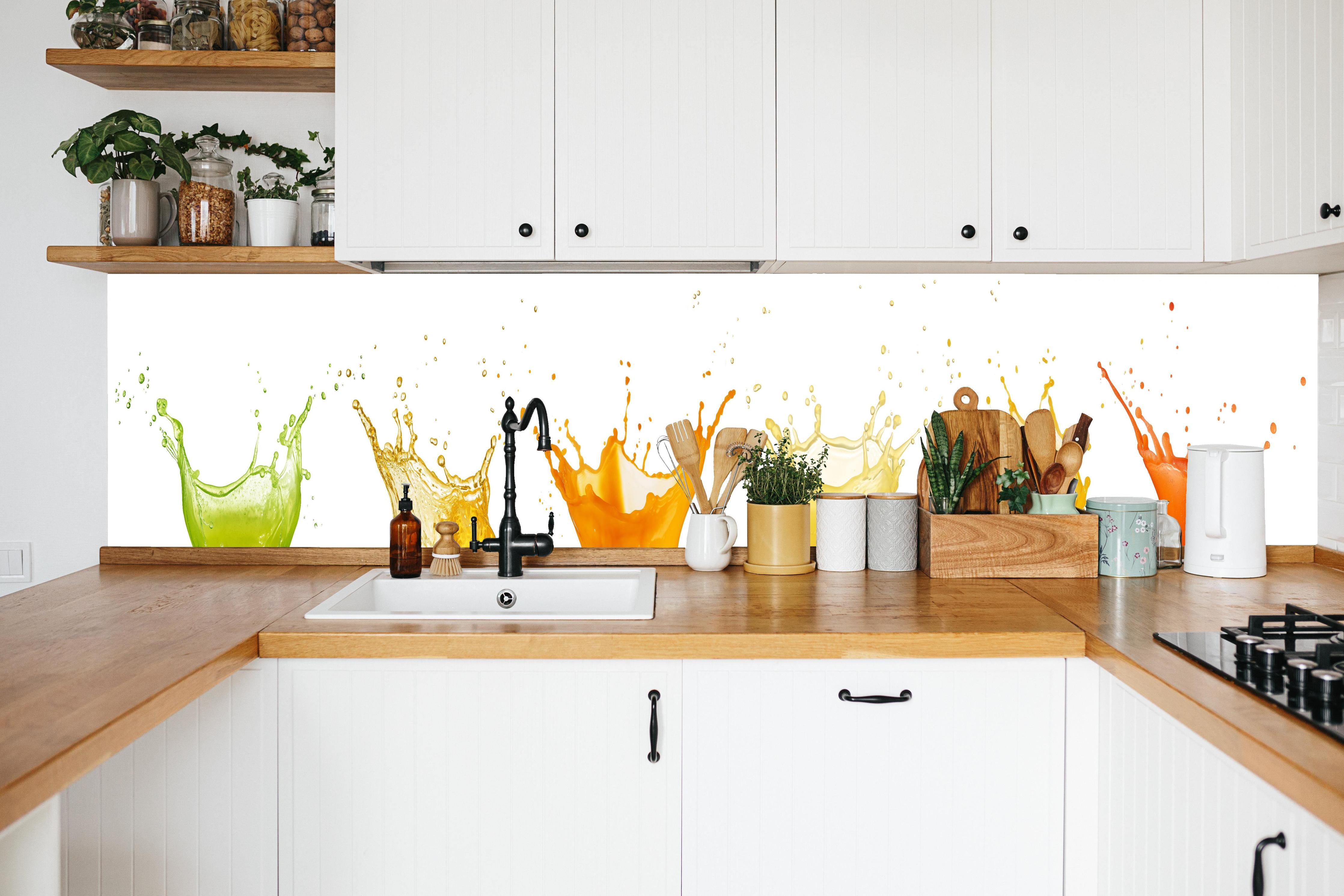 Küche - Grün-Gelb-Orange Wassersplash in weißer Küche hinter Gewürzen und Kochlöffeln aus Holz