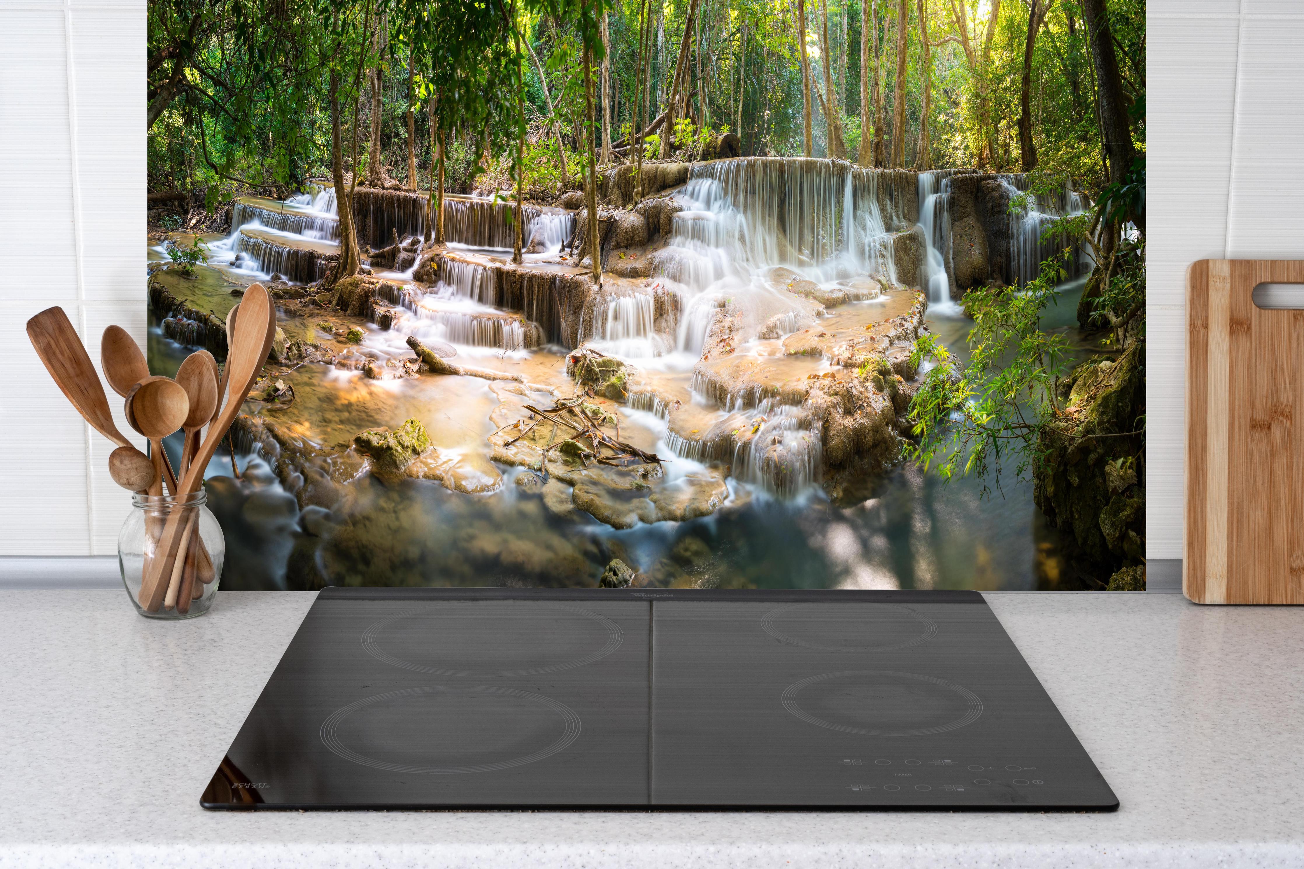 Küche - Grüner Wasserfall im Wald hinter Cerankochfeld und Holz-Kochutensilien