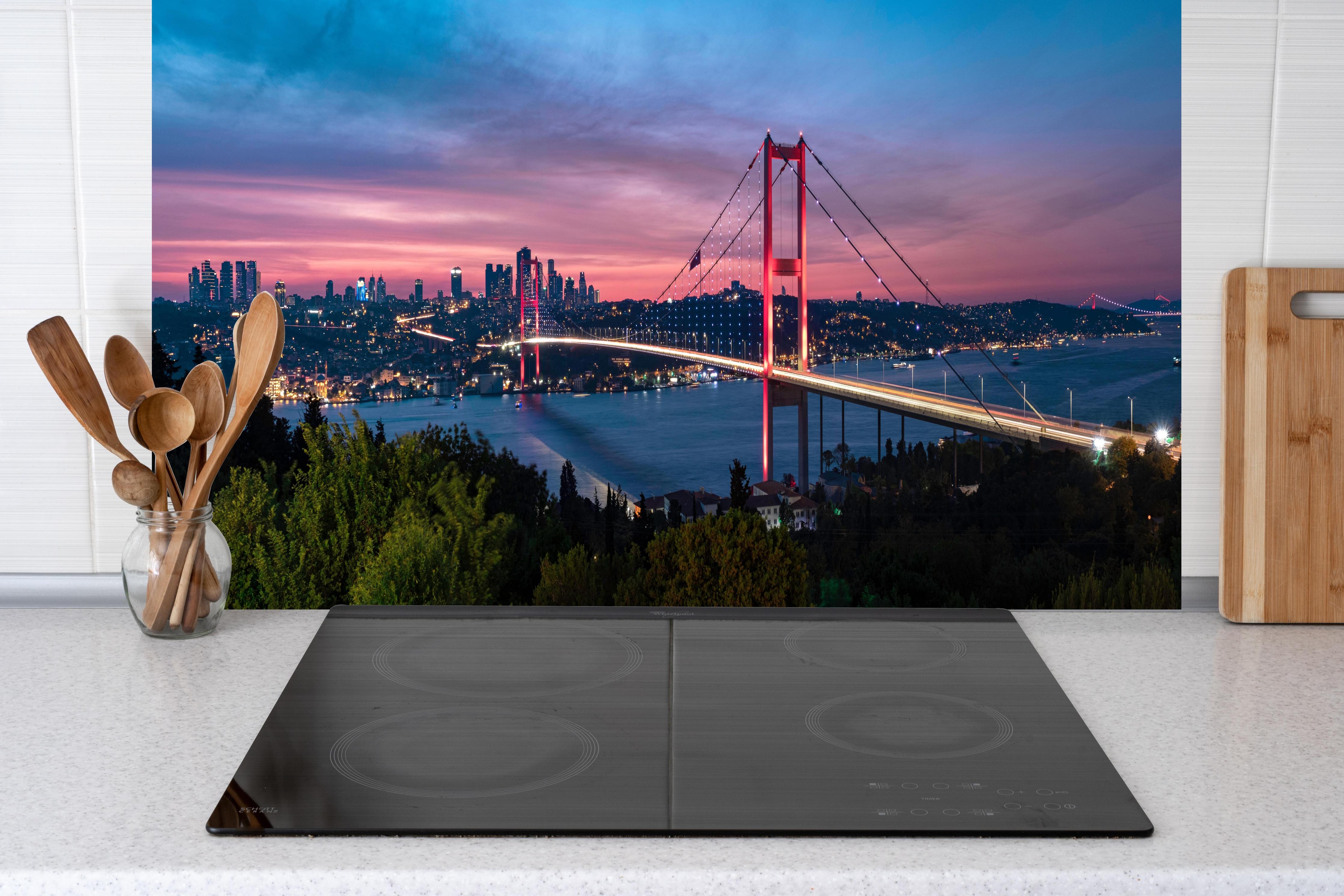 Küche - Istanbul Bosporusbrücke bei Dämmerung hinter Cerankochfeld und Holz-Kochutensilien