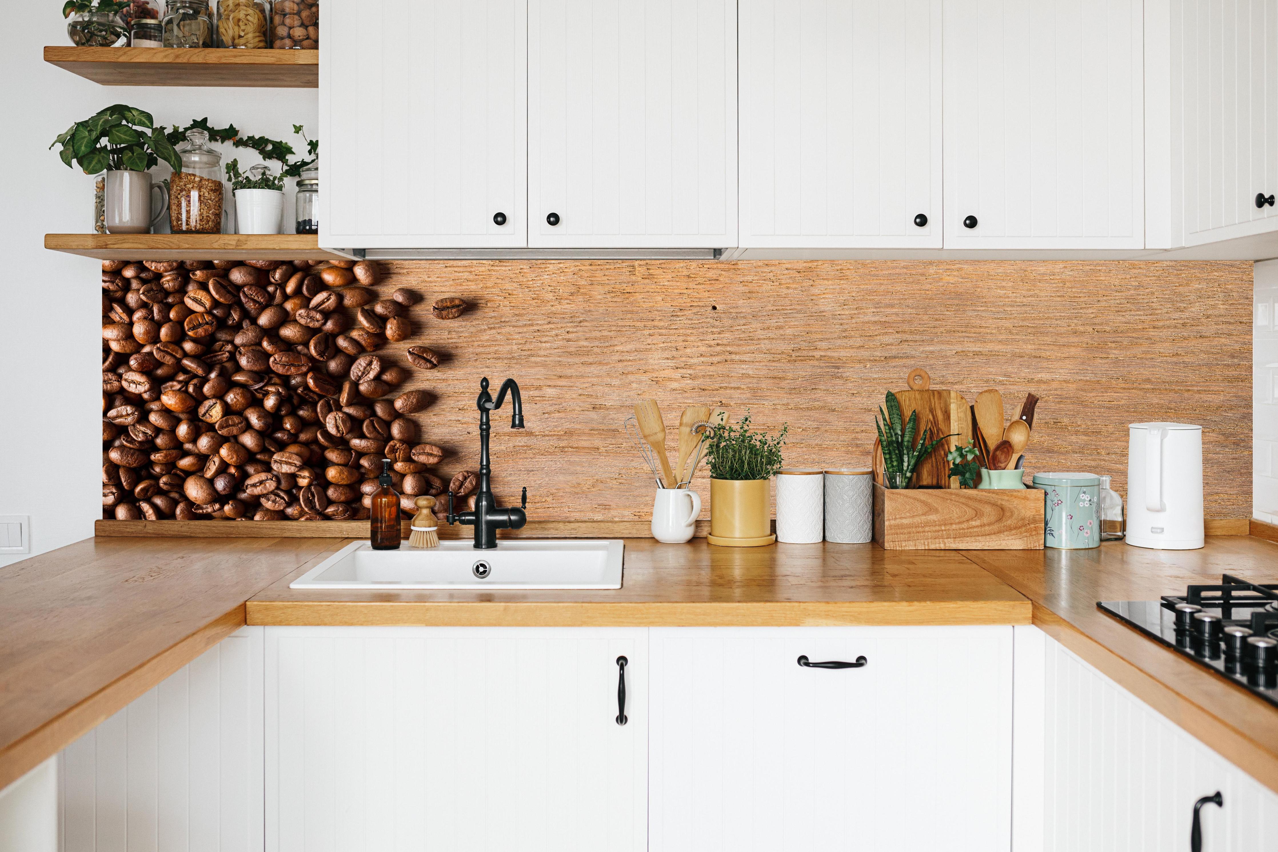 Küche - Kaffeebohnen auf Holz in weißer Küche hinter Gewürzen und Kochlöffeln aus Holz
