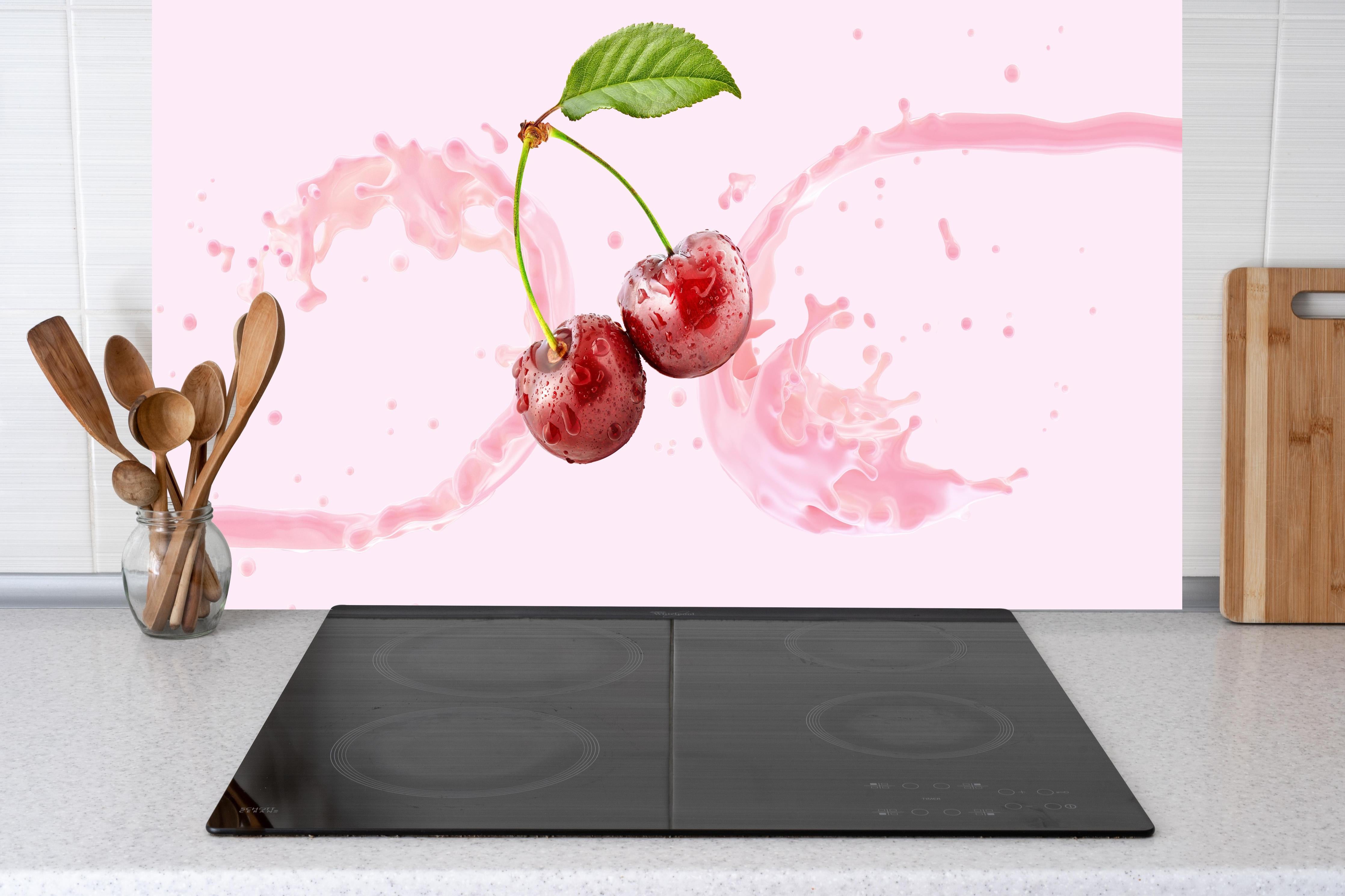 Küche - Kirsch-Milch-Splash in Rosa hinter Cerankochfeld und Holz-Kochutensilien