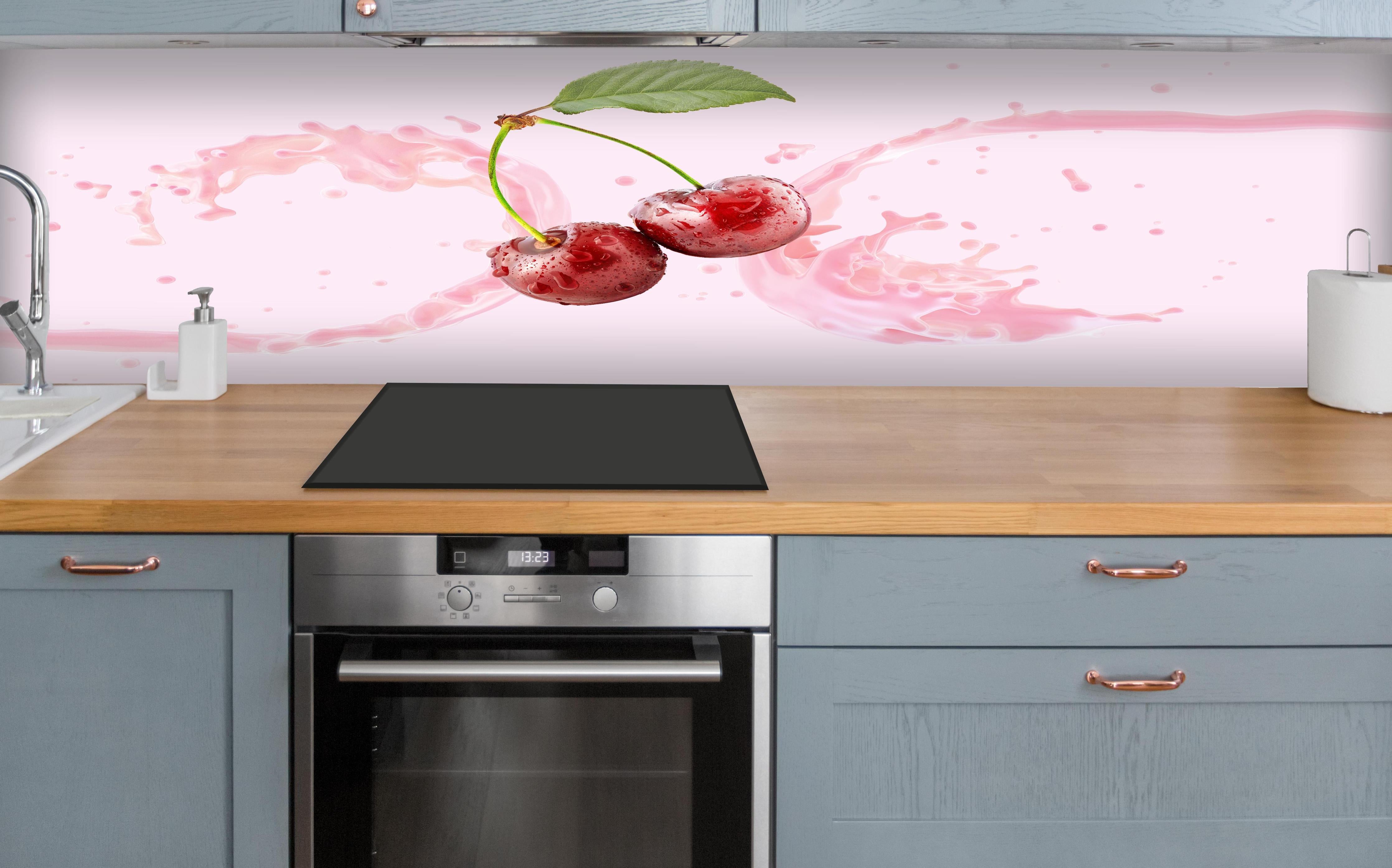 Küche - Kirsch-Milch-Splash in Rosa über polierter Holzarbeitsplatte mit Cerankochfeld