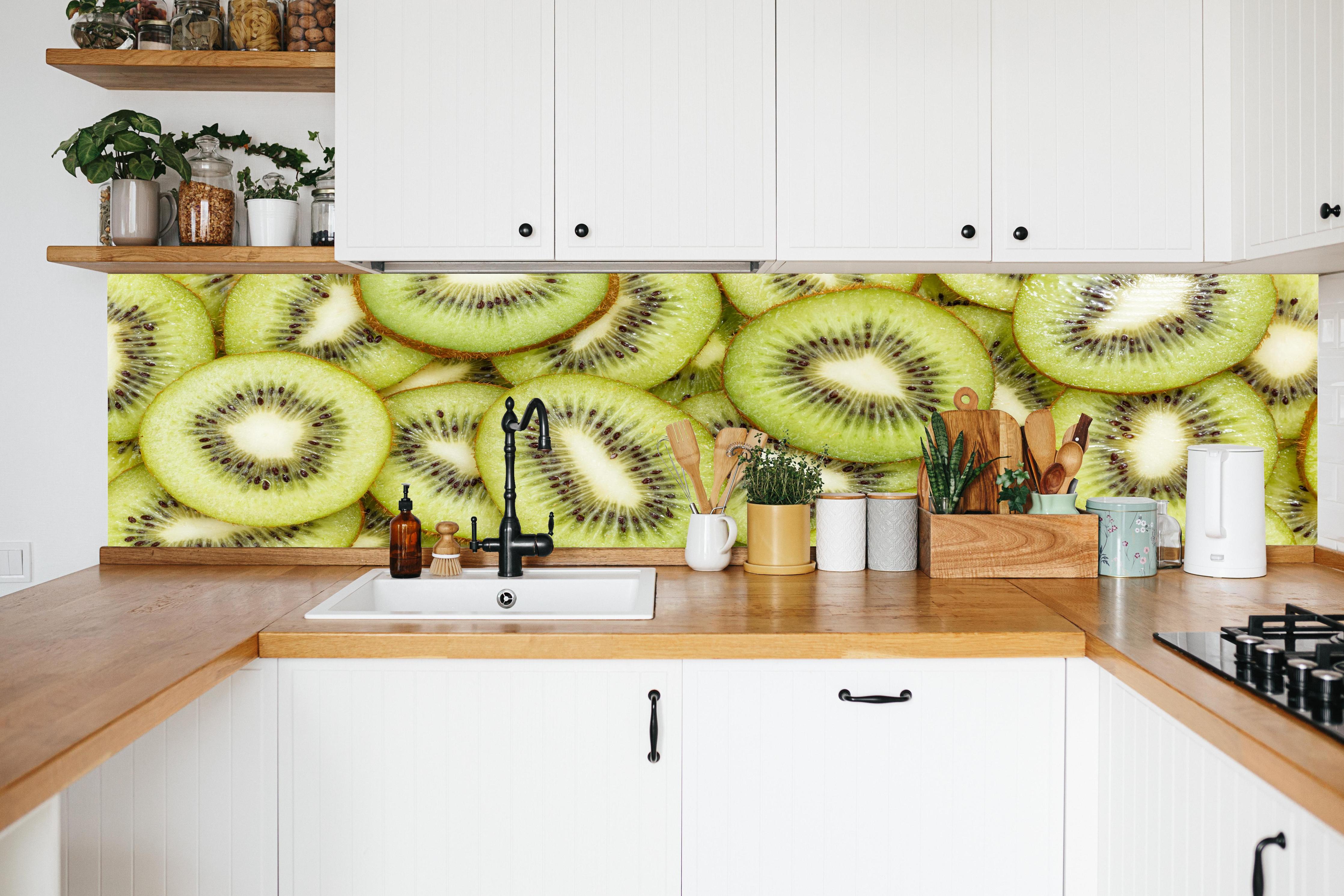 Küche - Kiwi-Scheiben Grün Fruchtmuster in weißer Küche hinter Gewürzen und Kochlöffeln aus Holz