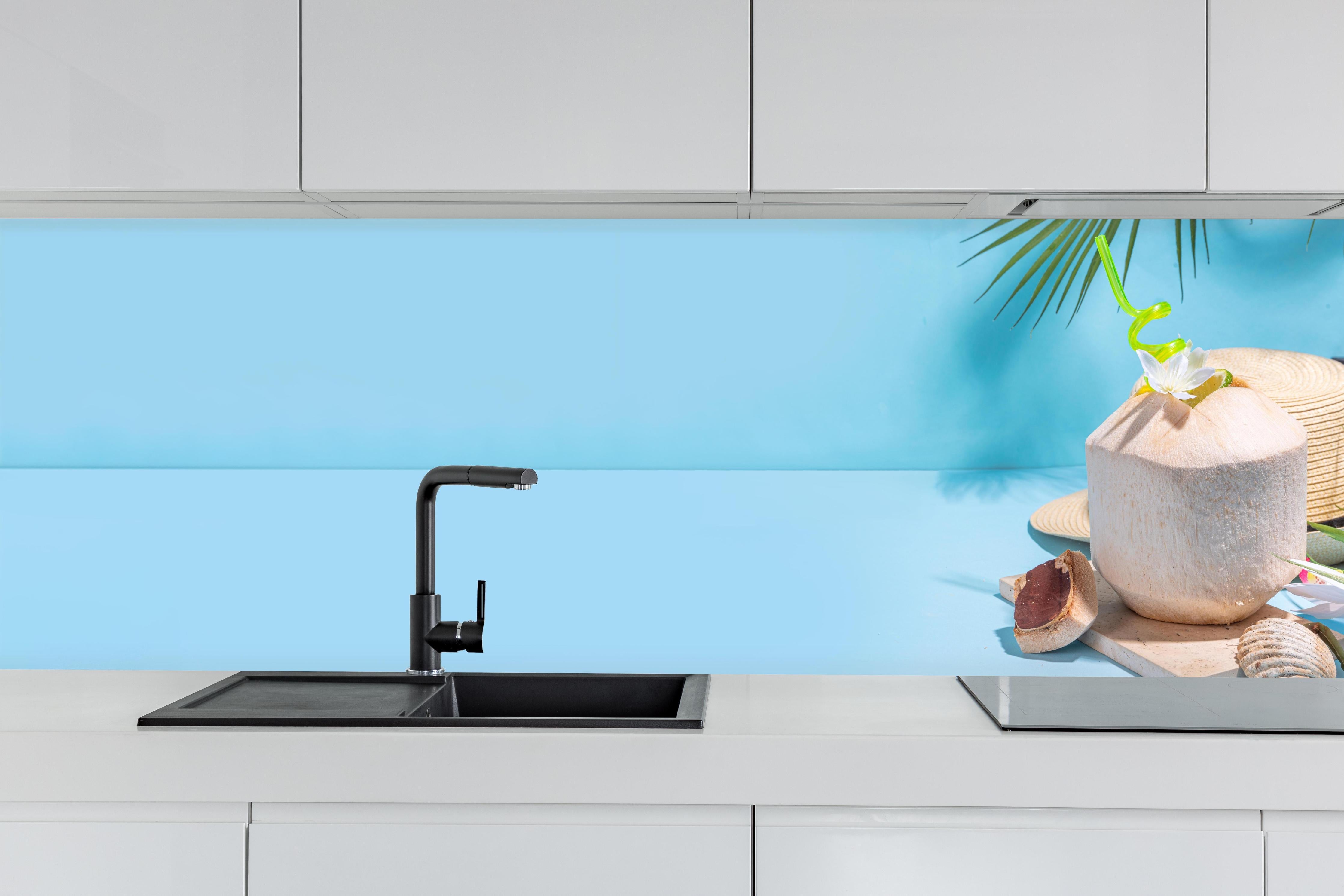 Küche - Kokosnuss-Limette Strandmotiv Blau hinter weißen Hochglanz-Küchenregalen und schwarzem Wasserhahn