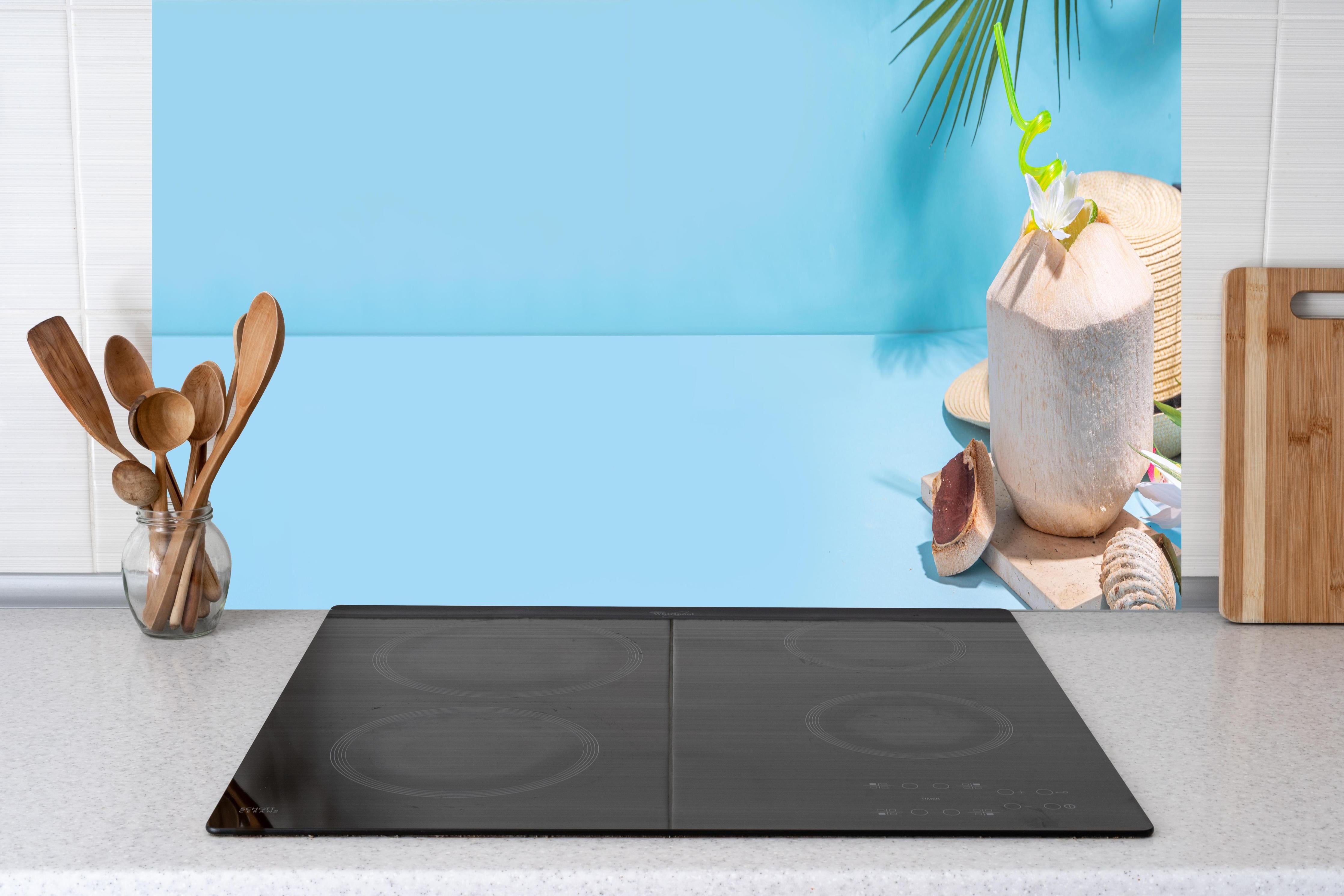 Küche - Kokosnuss-Limette Strandmotiv Blau hinter Cerankochfeld und Holz-Kochutensilien