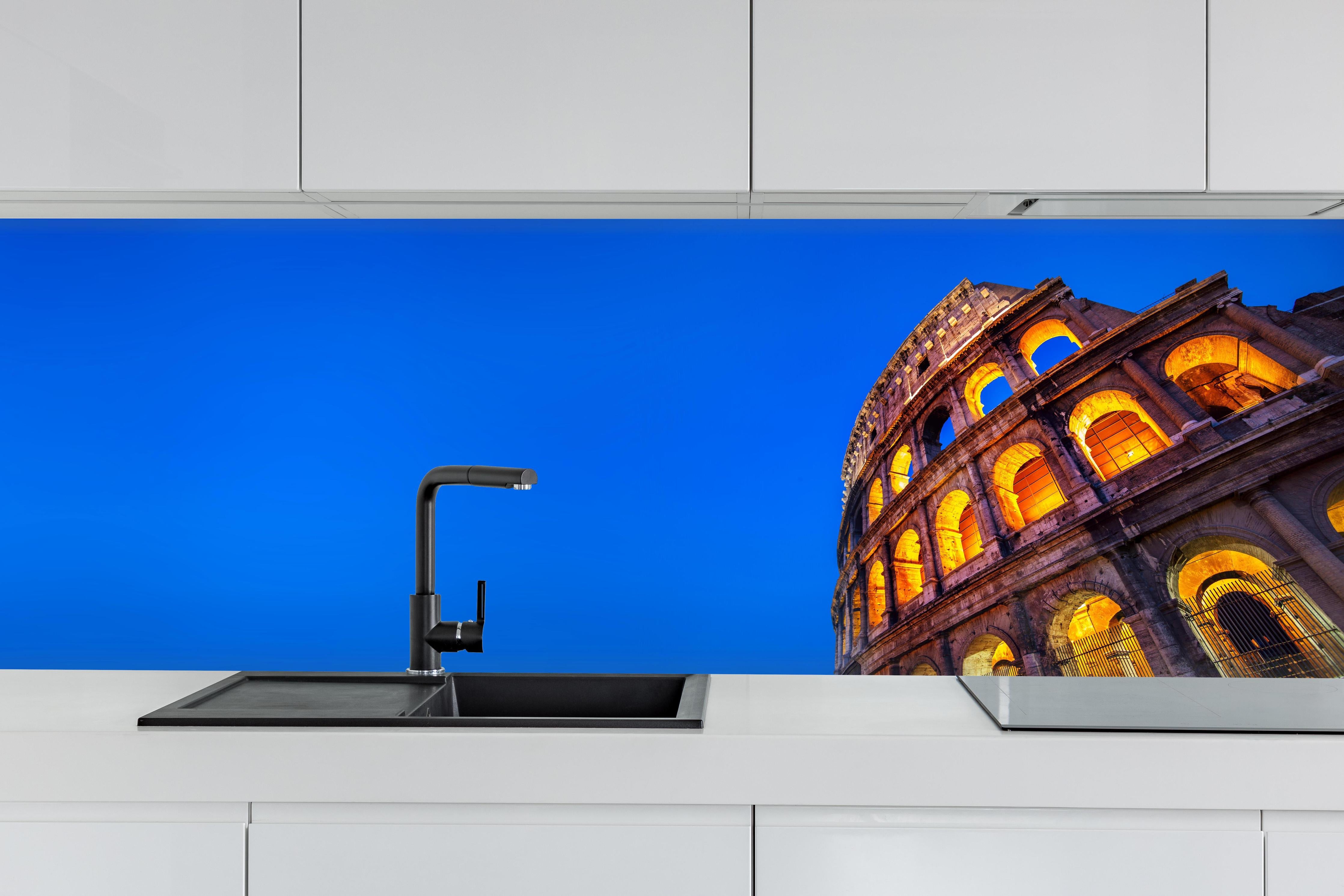 Küche - Kolosseum bei Nacht Blau-Orange hinter weißen Hochglanz-Küchenregalen und schwarzem Wasserhahn
