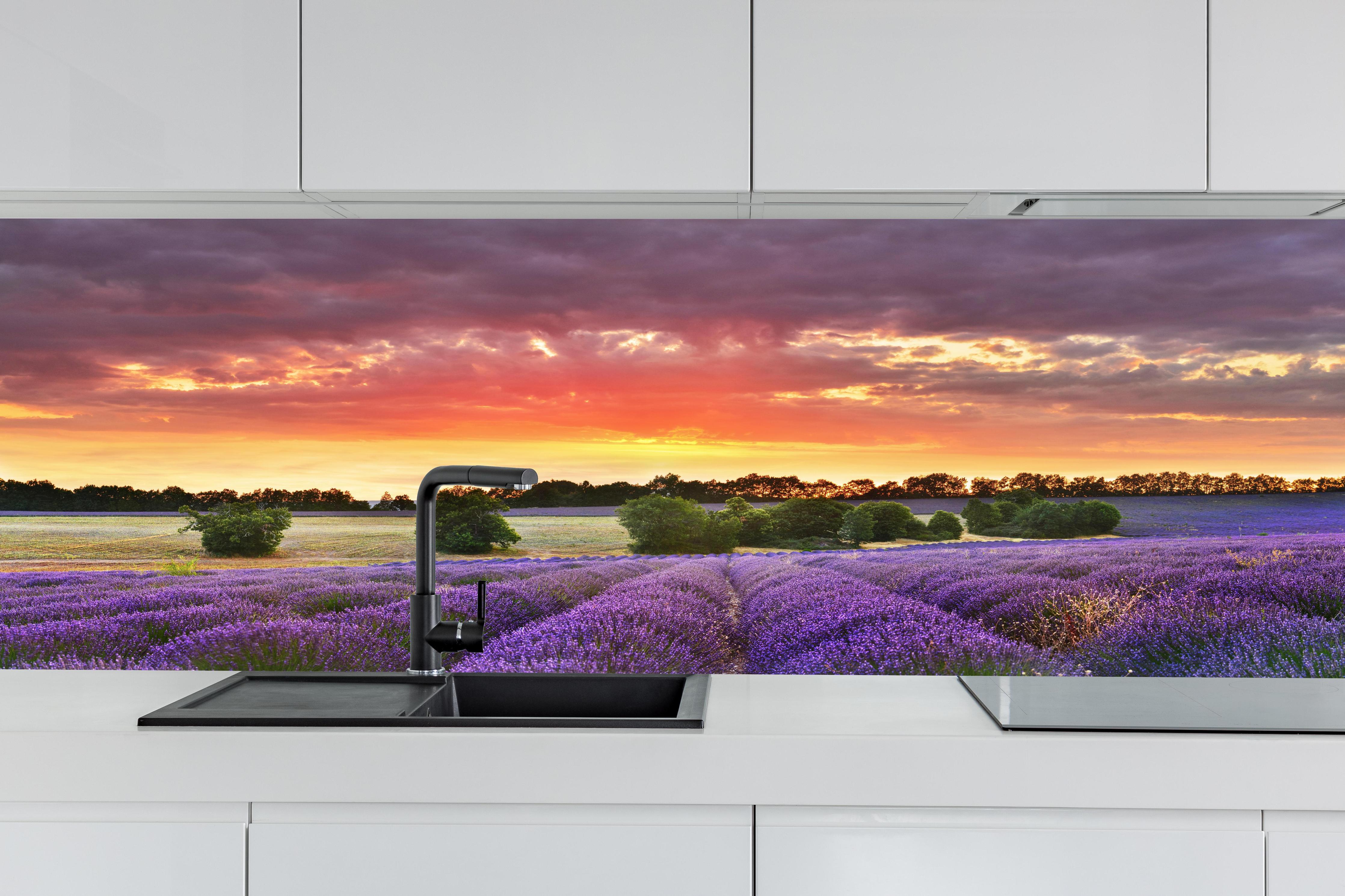 Küche - Lavendelfeld bei Sonnenuntergang hinter weißen Hochglanz-Küchenregalen und schwarzem Wasserhahn