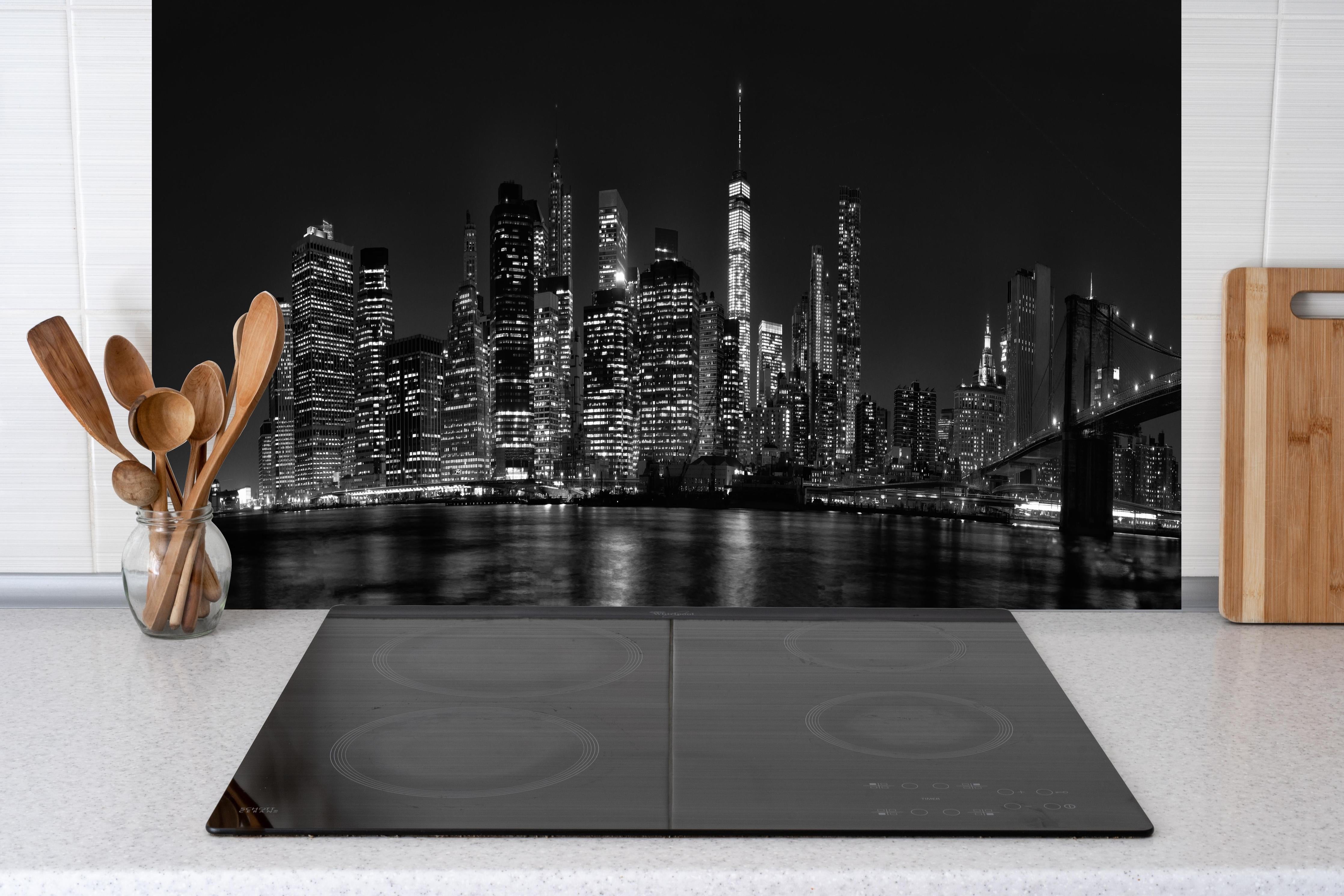 Küche - Manhattan Skyline Schwarz-Weiß hinter Cerankochfeld und Holz-Kochutensilien
