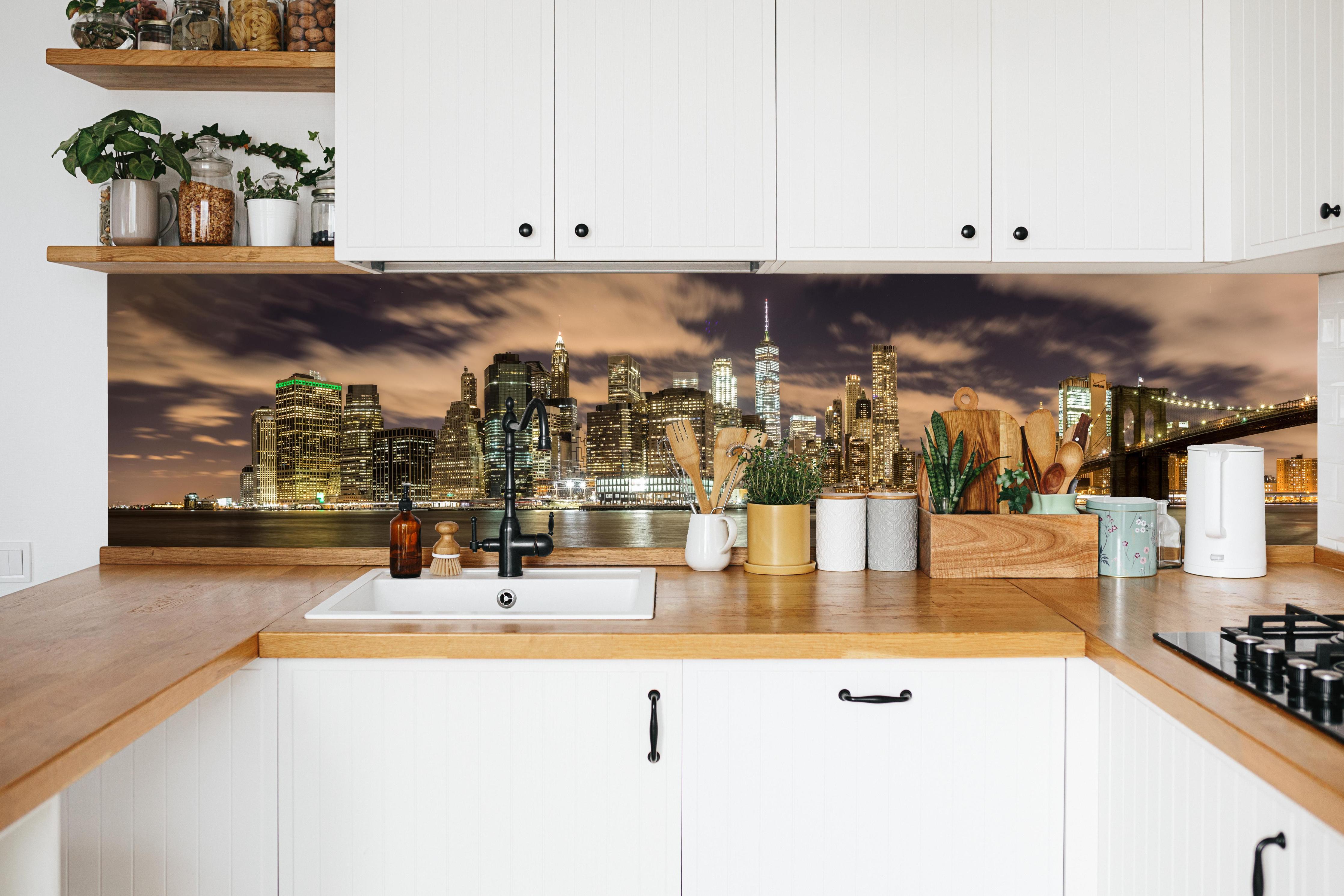 Küche - Manhattan Skyline im Glanz der Nacht in weißer Küche hinter Gewürzen und Kochlöffeln aus Holz