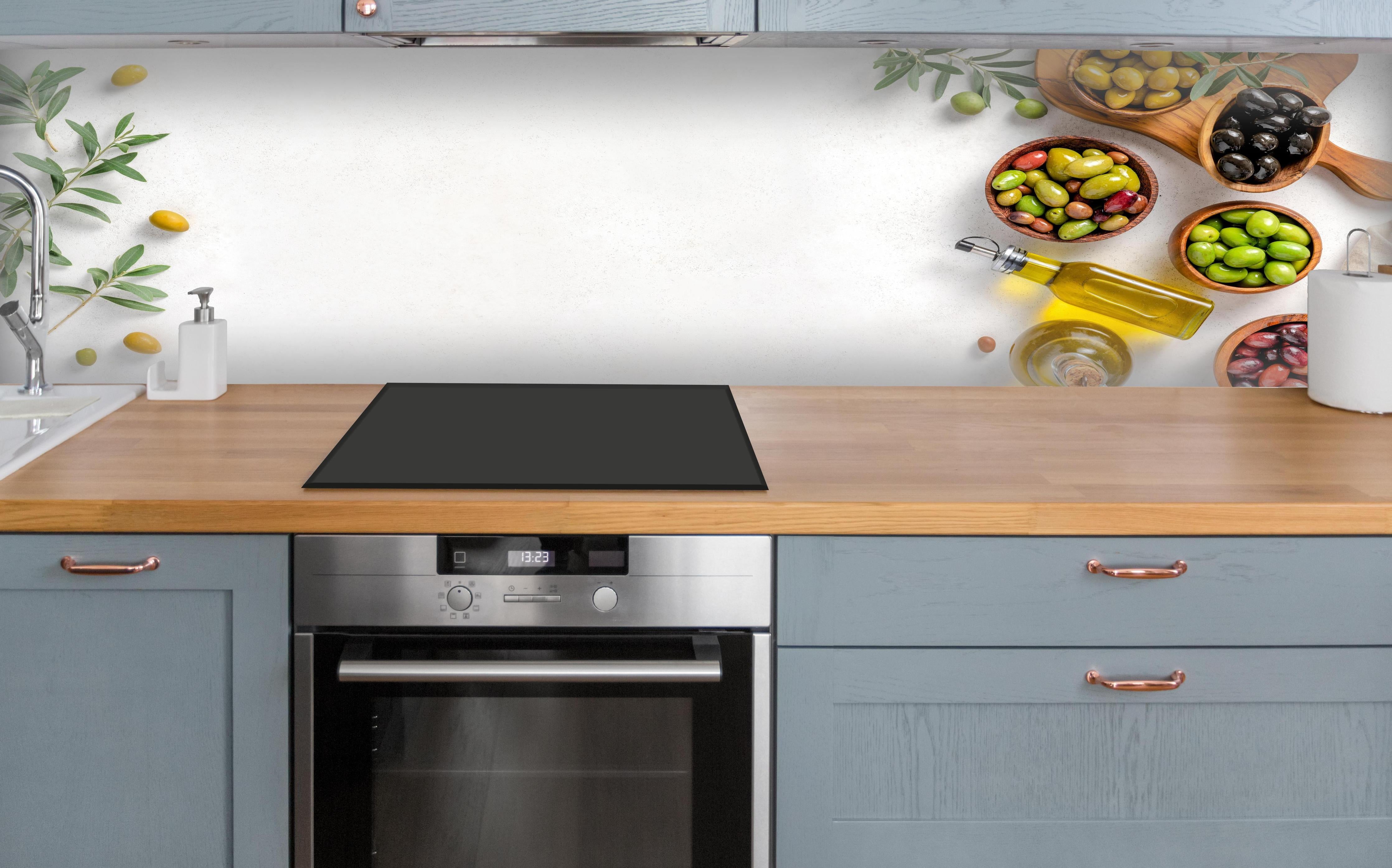 Küche - Mediterrane Oliven auf Weiß über polierter Holzarbeitsplatte mit Cerankochfeld