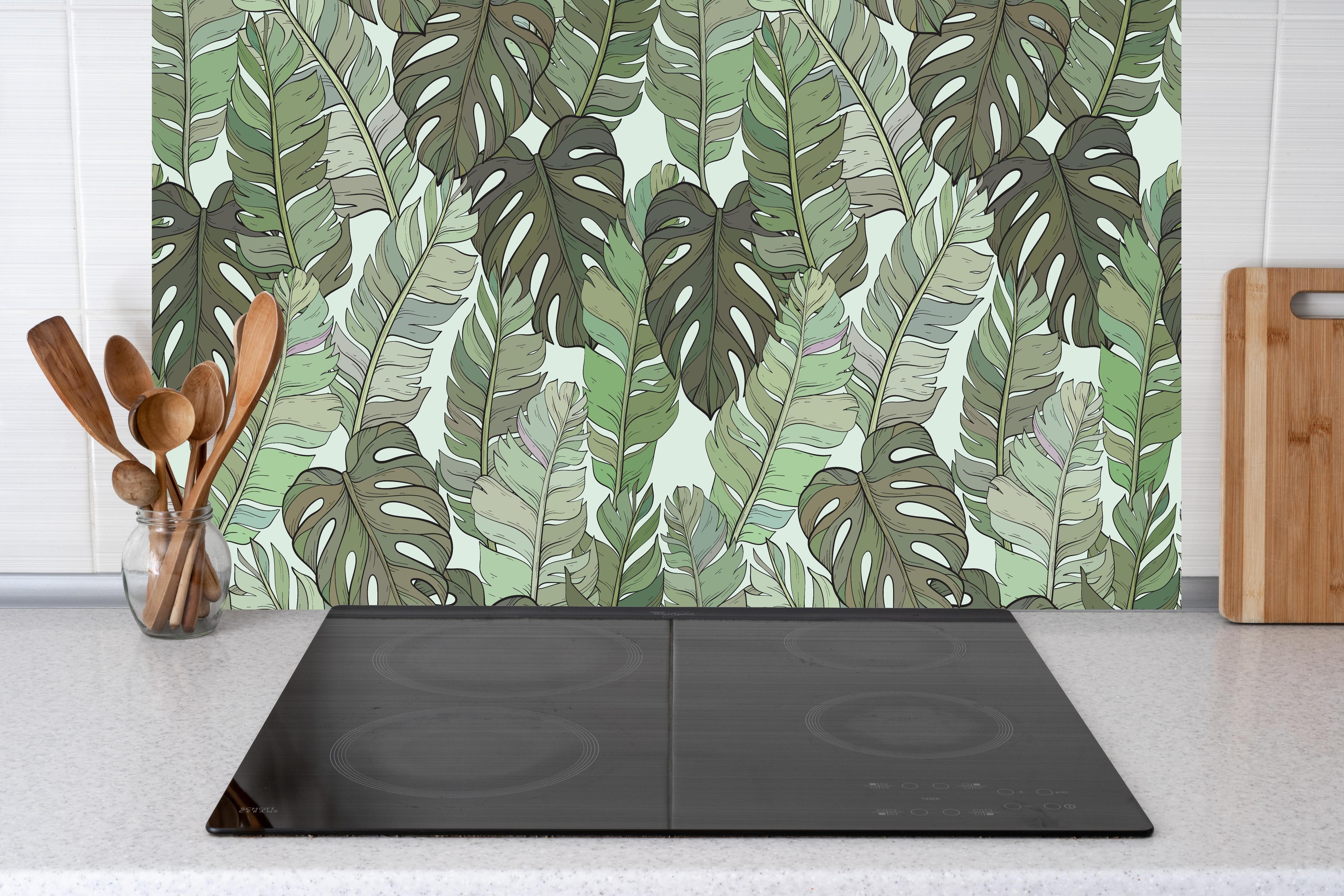 Küche - Monstera-Blätter – Tropische Eleganz hinter Cerankochfeld und Holz-Kochutensilien