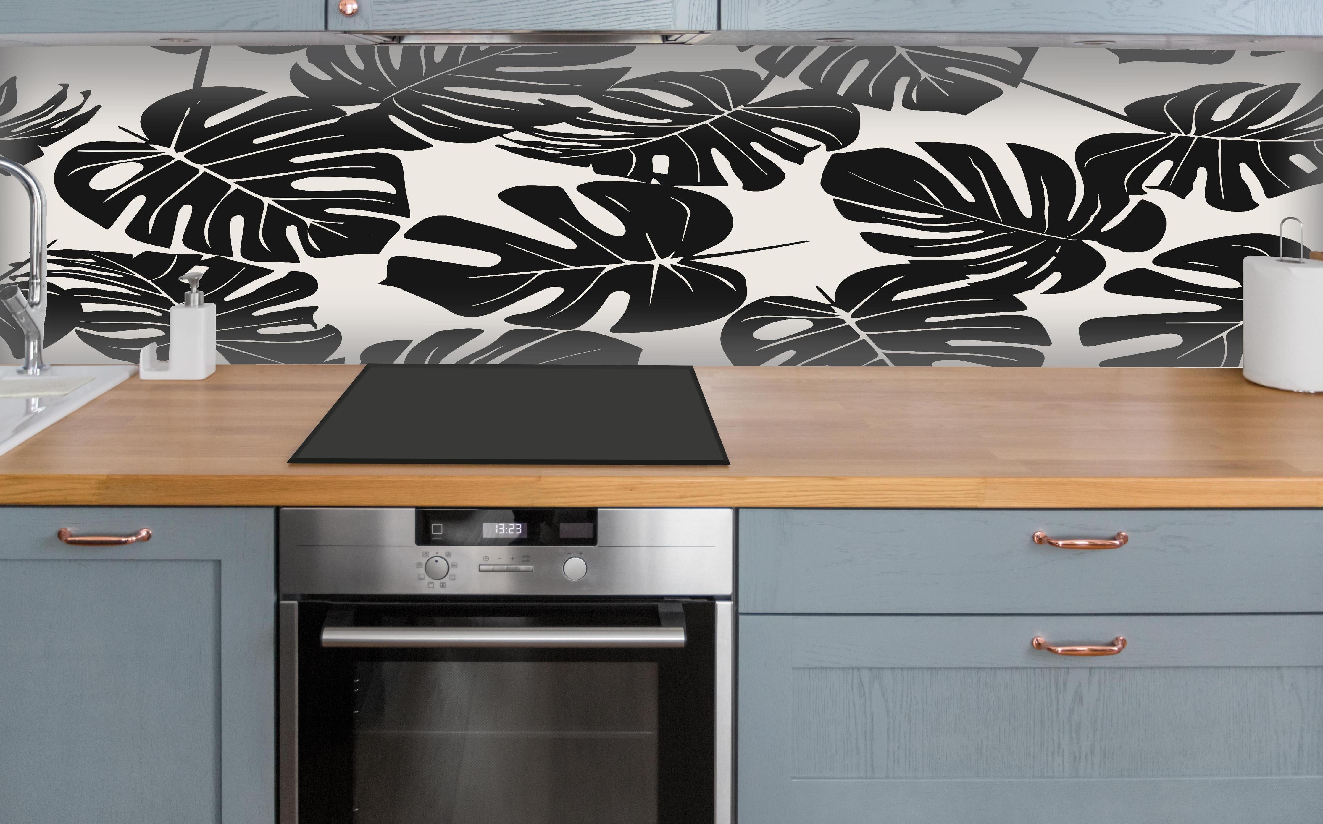 Küche - Monstera Schwarz-Beige Muster über polierter Holzarbeitsplatte mit Cerankochfeld