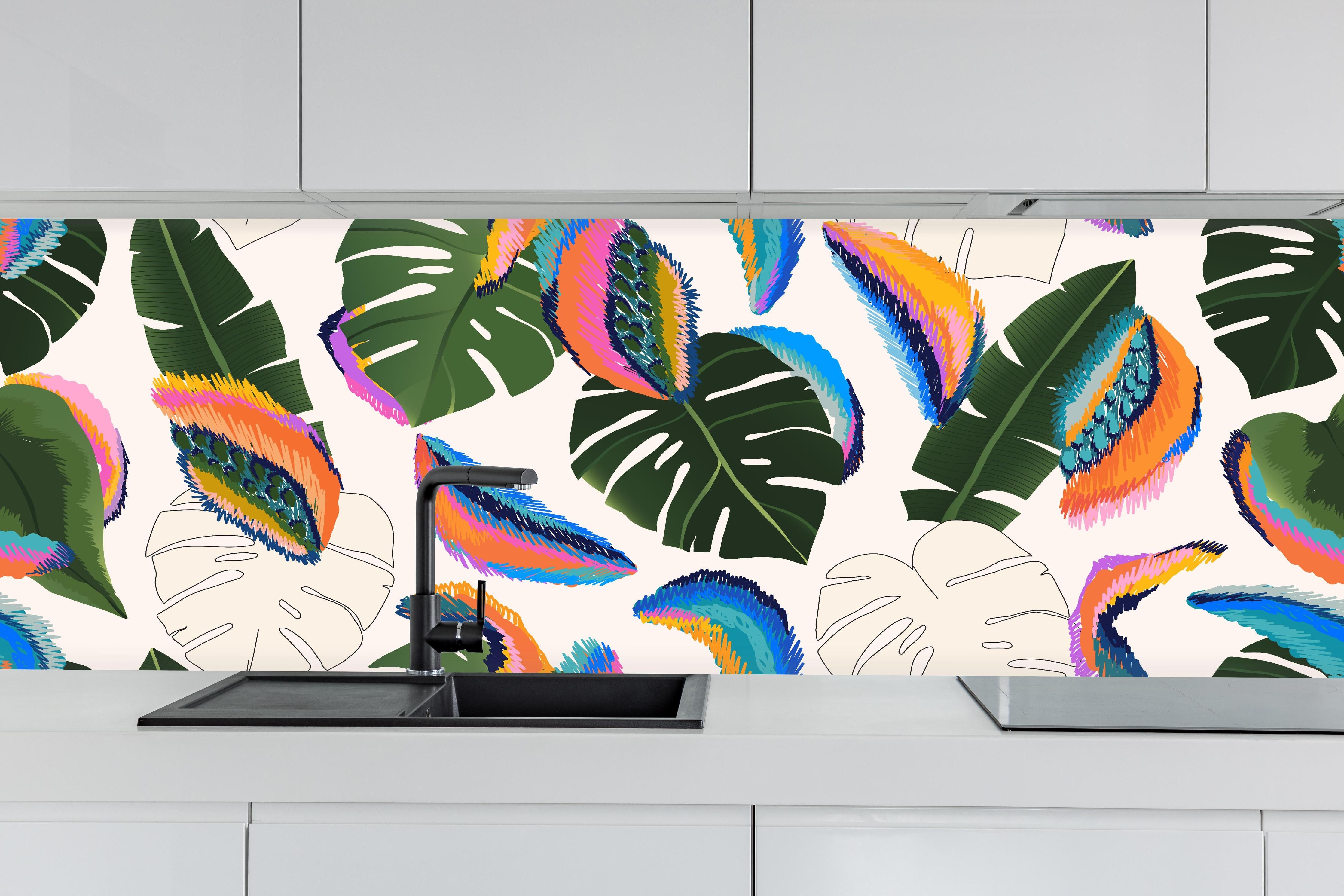 Küche - Monstera Tropic Bunte Blätter hinter weißen Hochglanz-Küchenregalen und schwarzem Wasserhahn