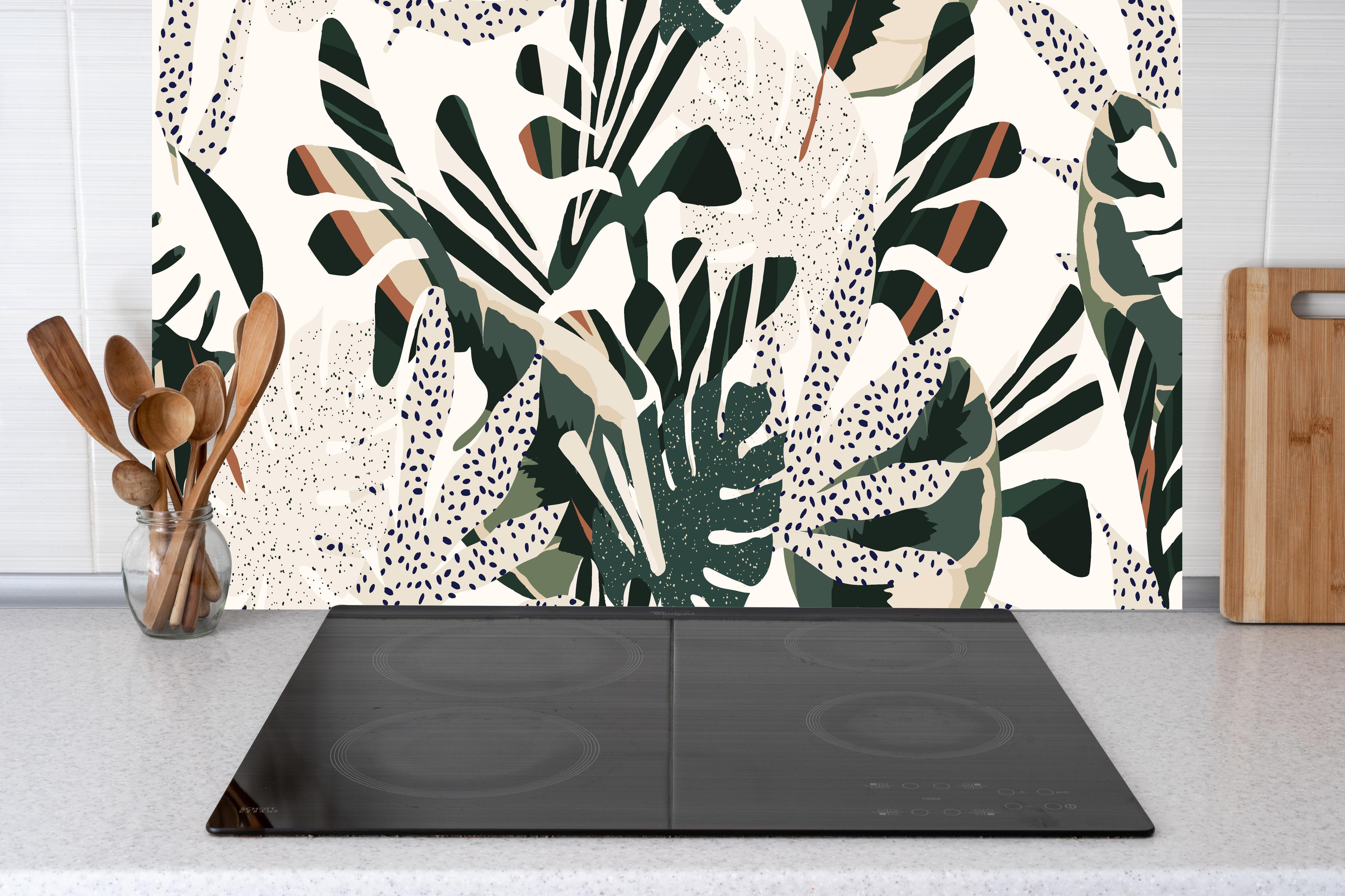 Küche - Monstera Tropic Grün-Beige hinter Cerankochfeld und Holz-Kochutensilien