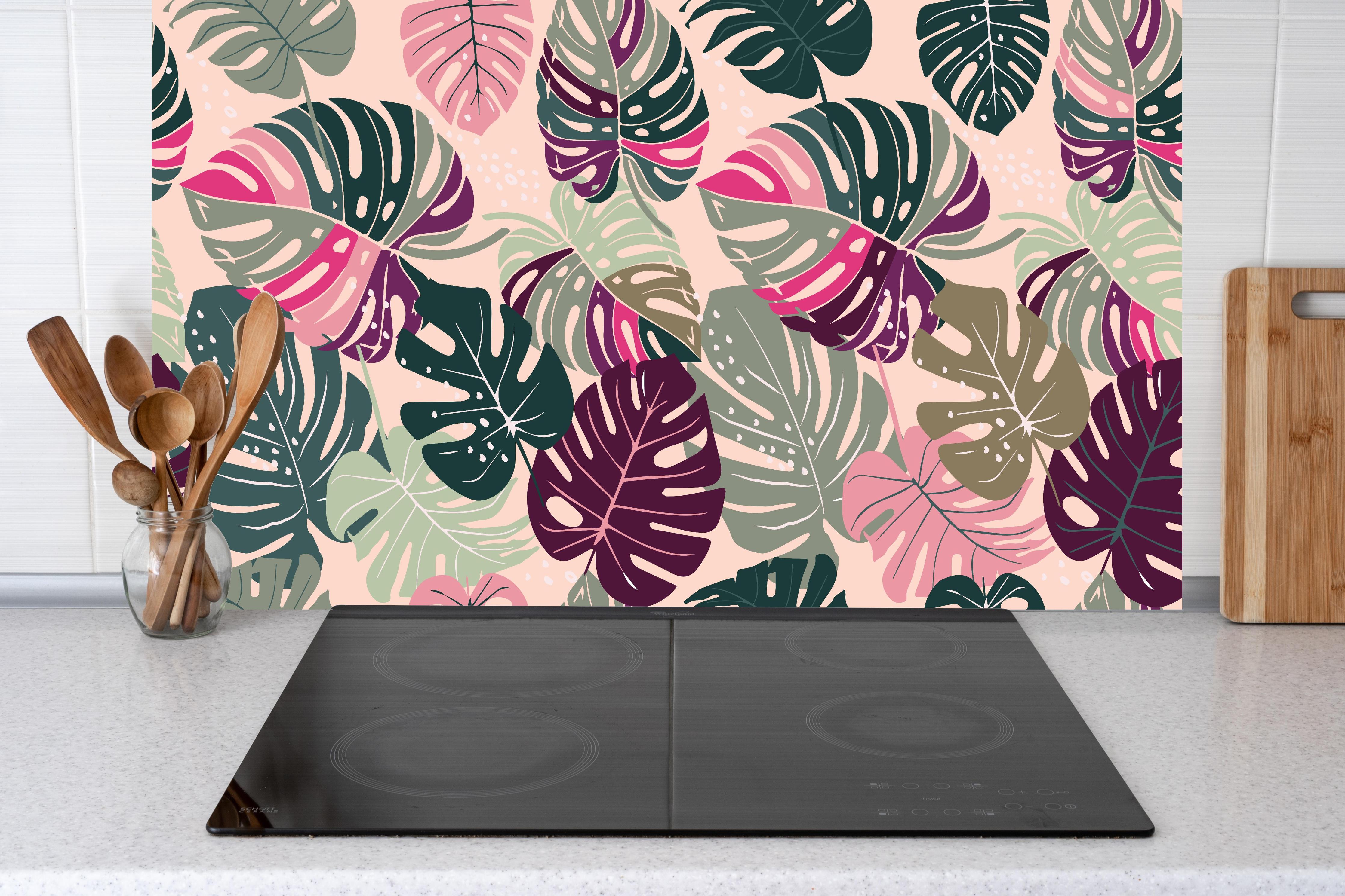 Küche - Monstera Tropic Rosa-Grün hinter Cerankochfeld und Holz-Kochutensilien