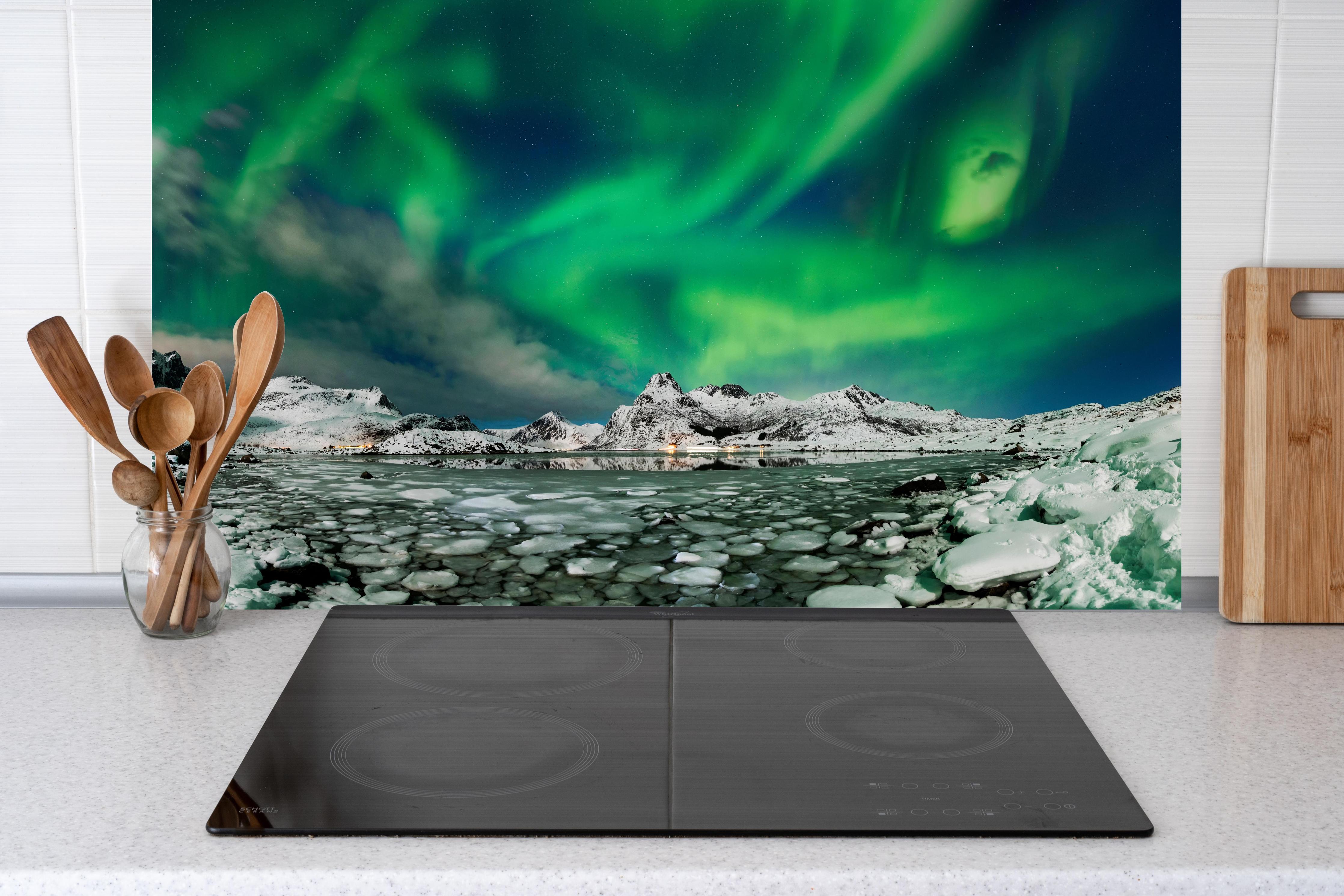 Küche - Nordlichter über arktischer Küste hinter Cerankochfeld und Holz-Kochutensilien