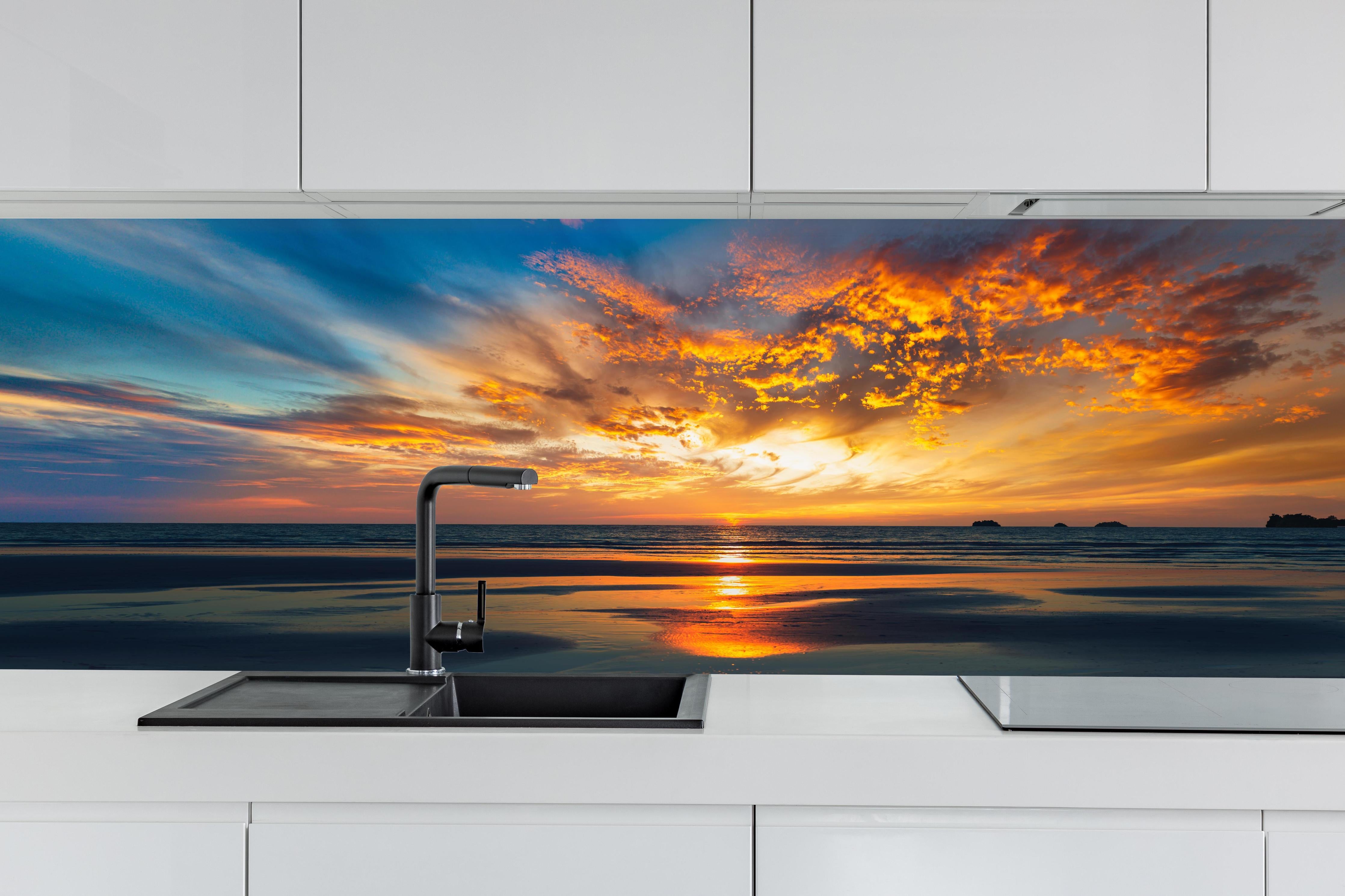 Küche - Panorama Sonnenuntergang am Meer hinter weißen Hochglanz-Küchenregalen und schwarzem Wasserhahn