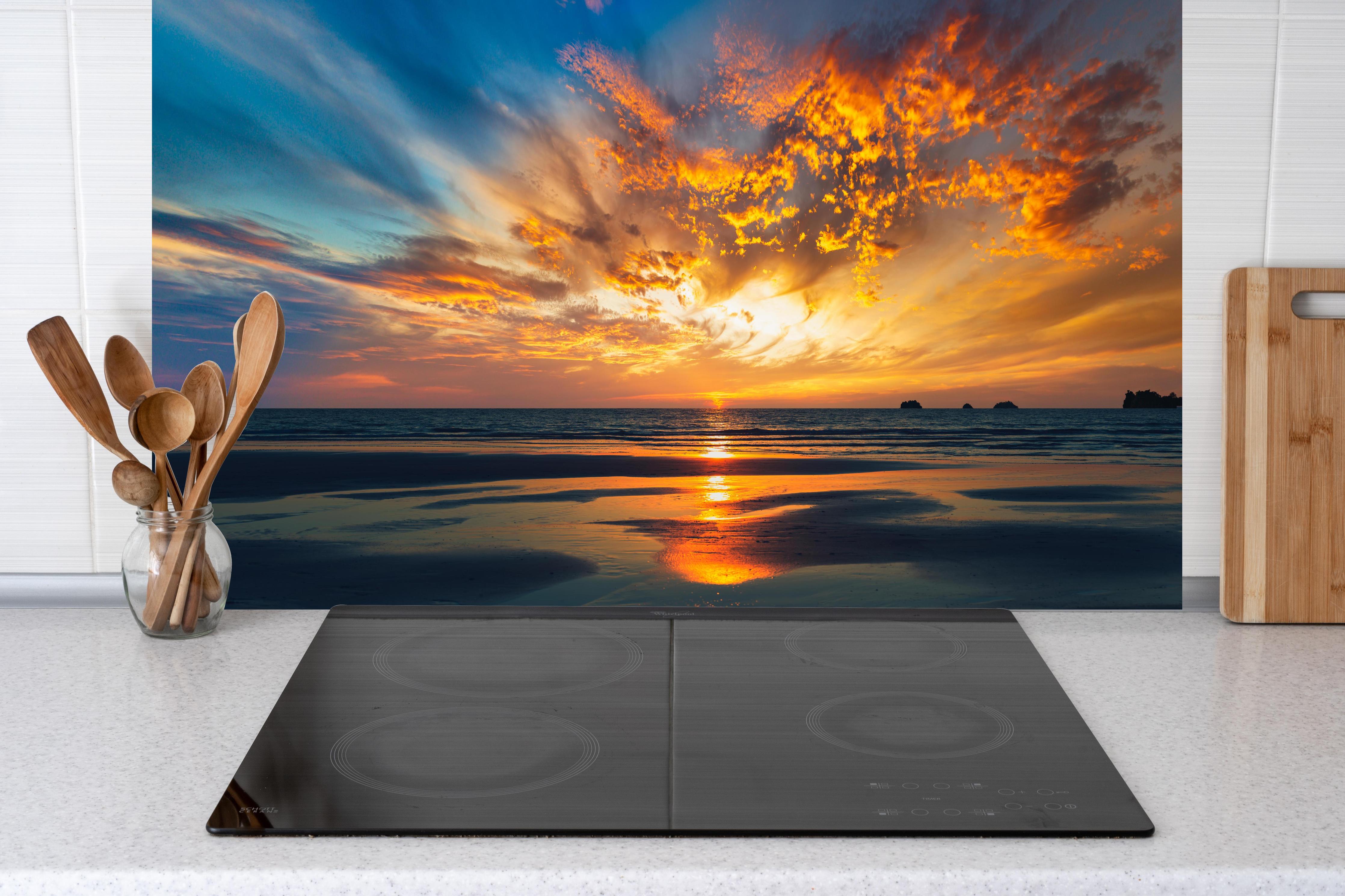 Küche - Panorama Sonnenuntergang am Meer hinter Cerankochfeld und Holz-Kochutensilien