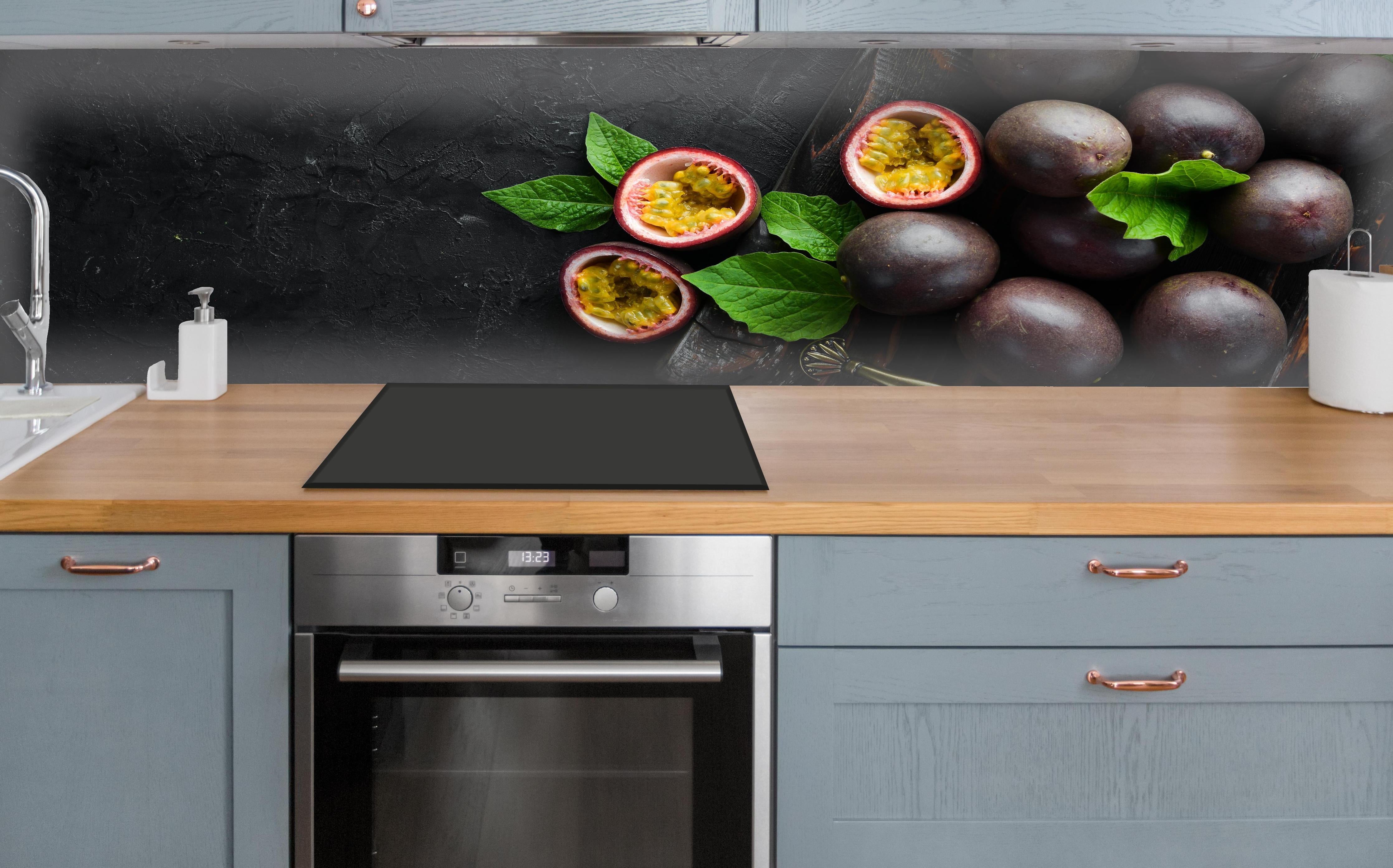 Küche - Passionsfrüchte Lila-Gelb-Grün über polierter Holzarbeitsplatte mit Cerankochfeld